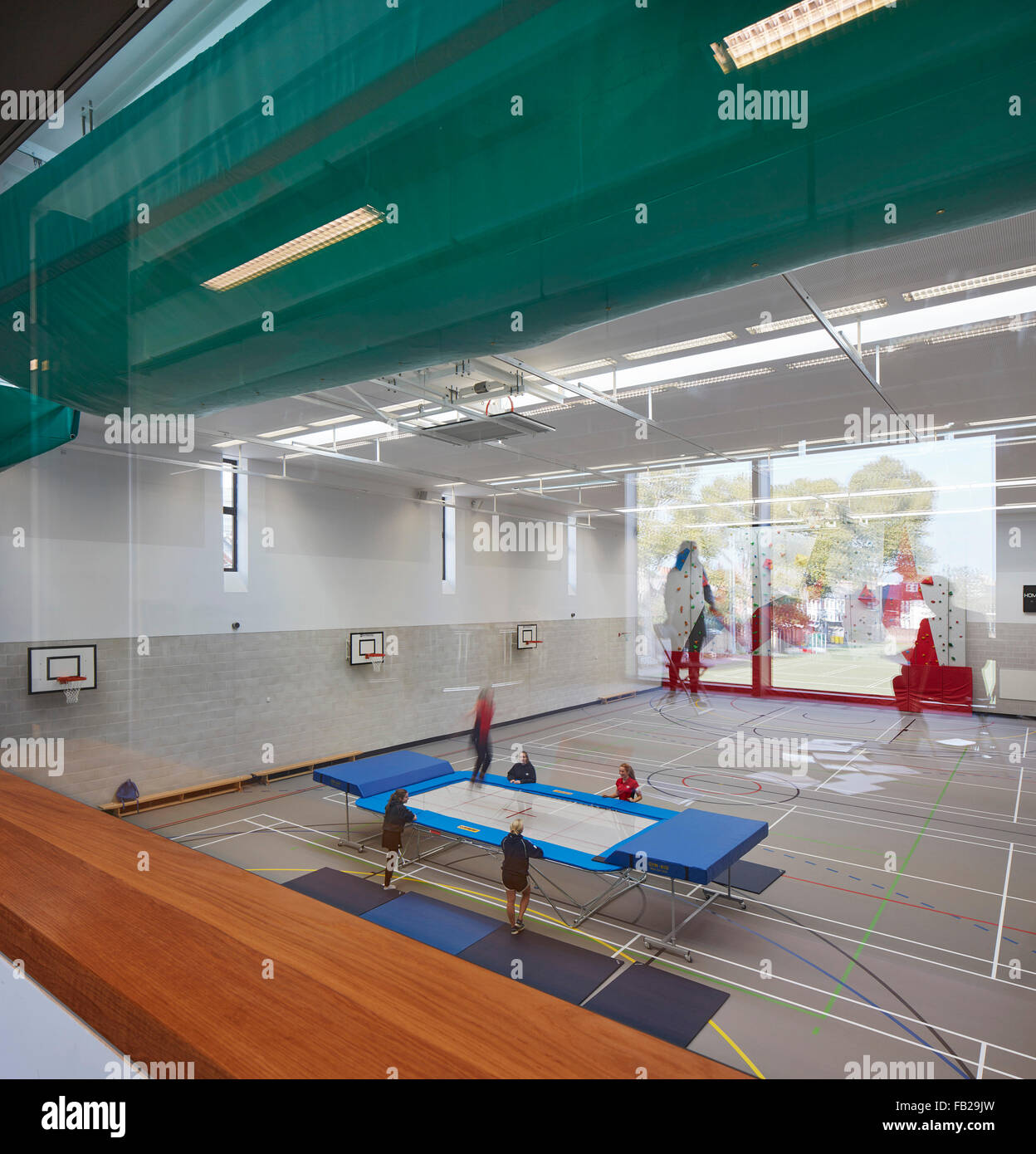 Sporthalle mit Mädchen Trampolinspringen von Obergeschoss Proberaum gesehen. Godolphin & Latymer Schule, London, Vereinigtes Königreich. Stockfoto