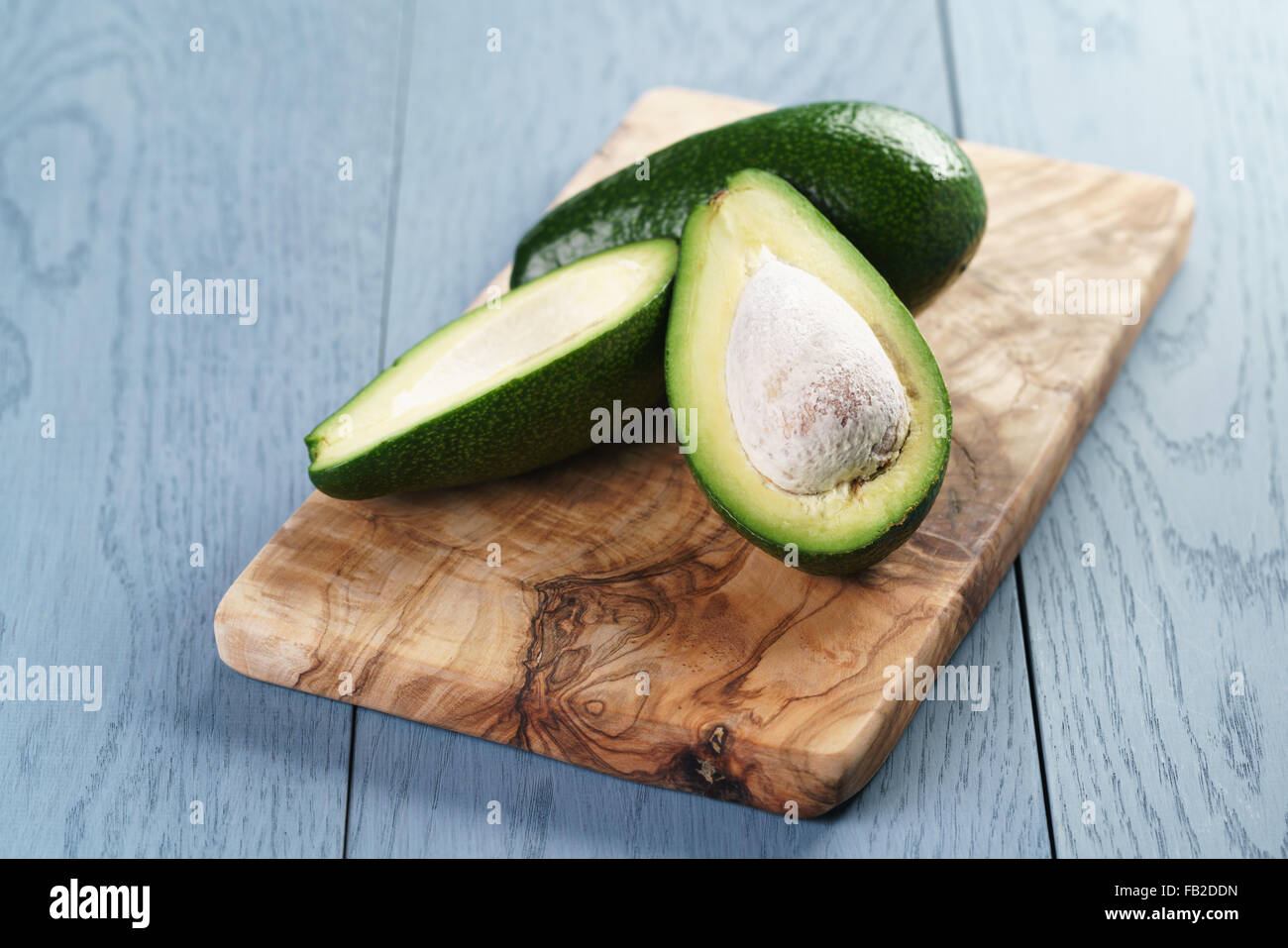 Reife Avocado, die Hälfte auf Schneidebrett geschnitten Stockfoto