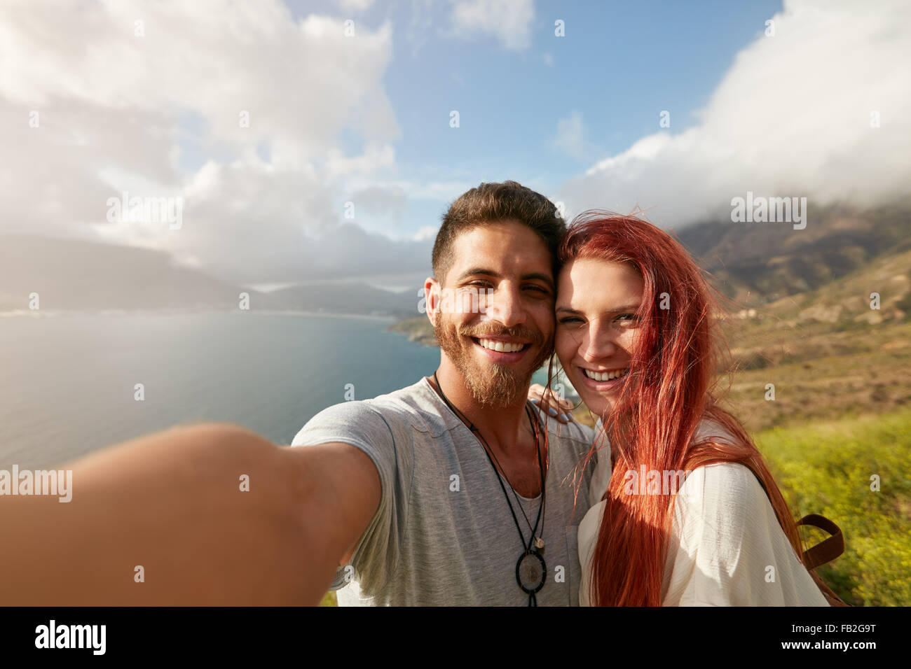 Fröhliches junges Paar unter einem Selfie im Freien. POV Mann hält eine Kamera, die ein Selbstporträt mit seiner Freundin erschossen. Stockfoto