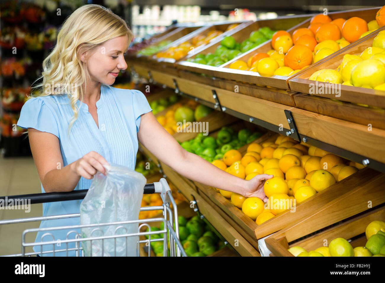 Lächelnde Frau nehmen Orangen Stockfoto