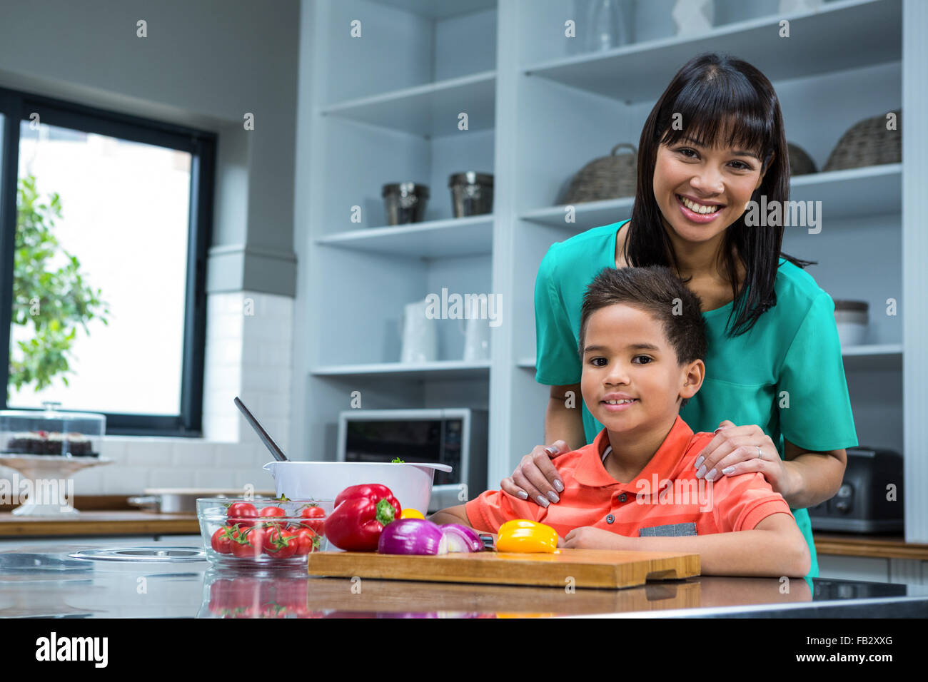 Lächelnde Frau mit ihrem Sohn Kochen Stockfoto
