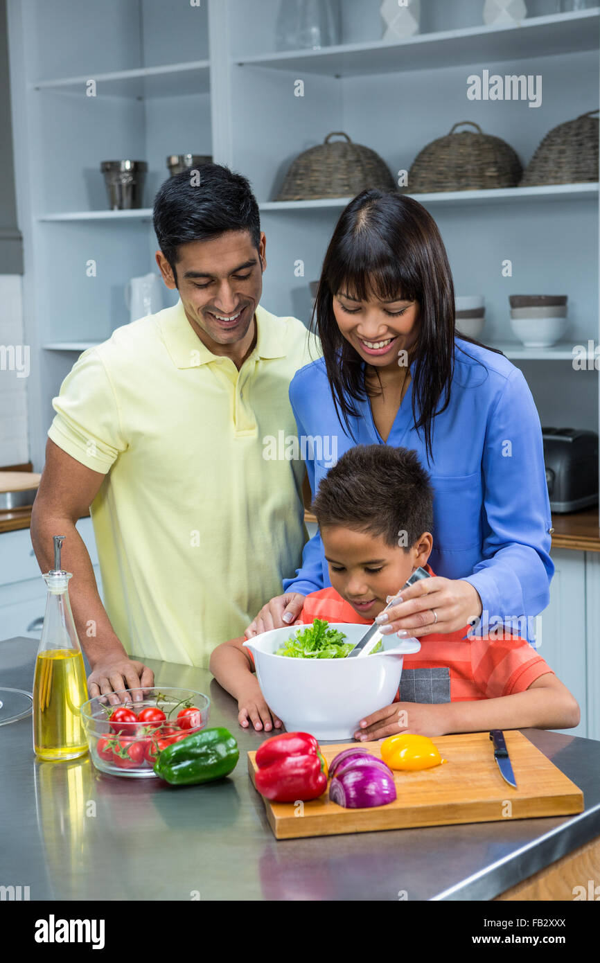 Glückliche Familie bereitet Salat in der Küche Stockfoto