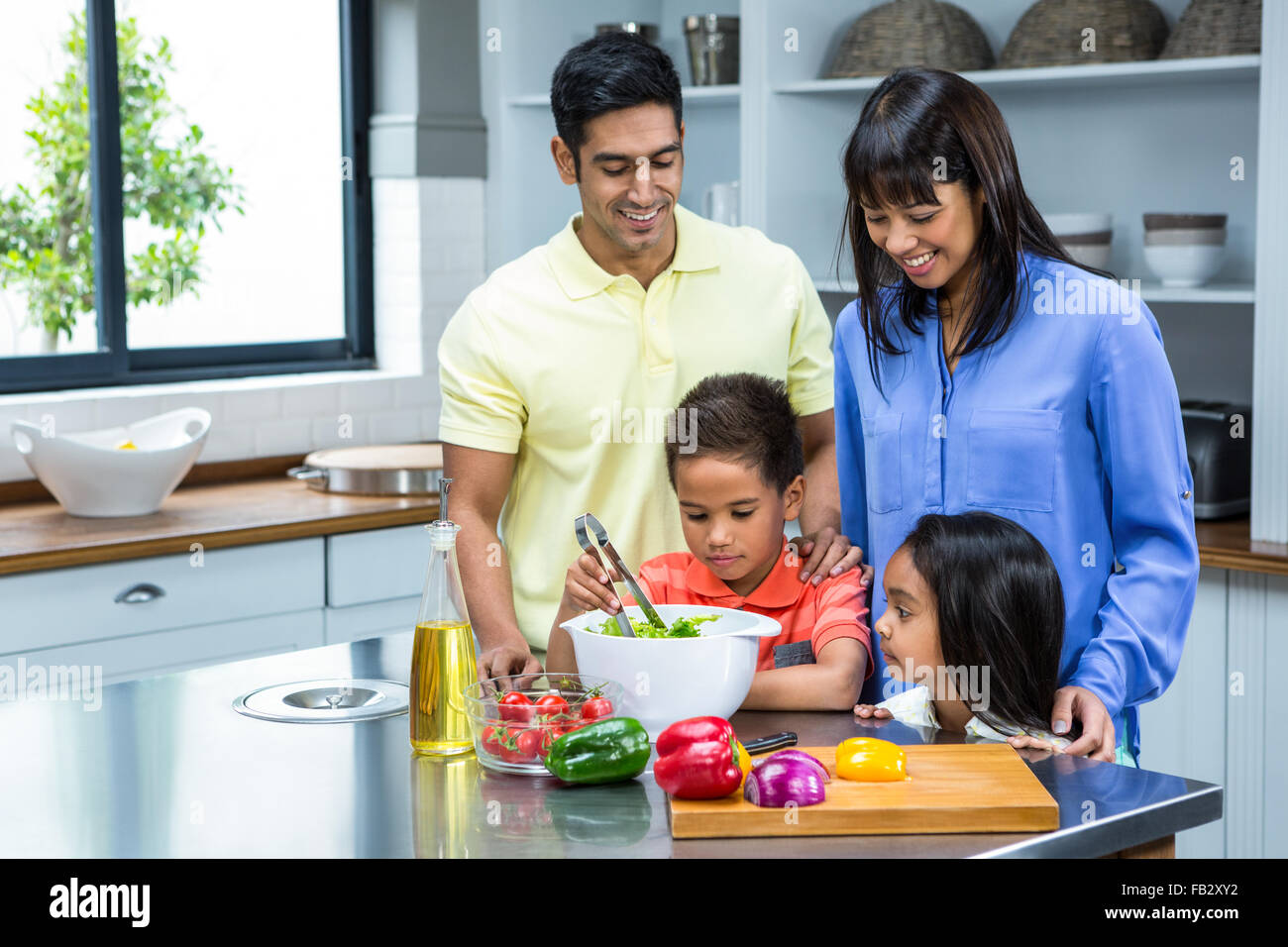 Glückliche Familie bereitet Salat in der Küche Stockfoto