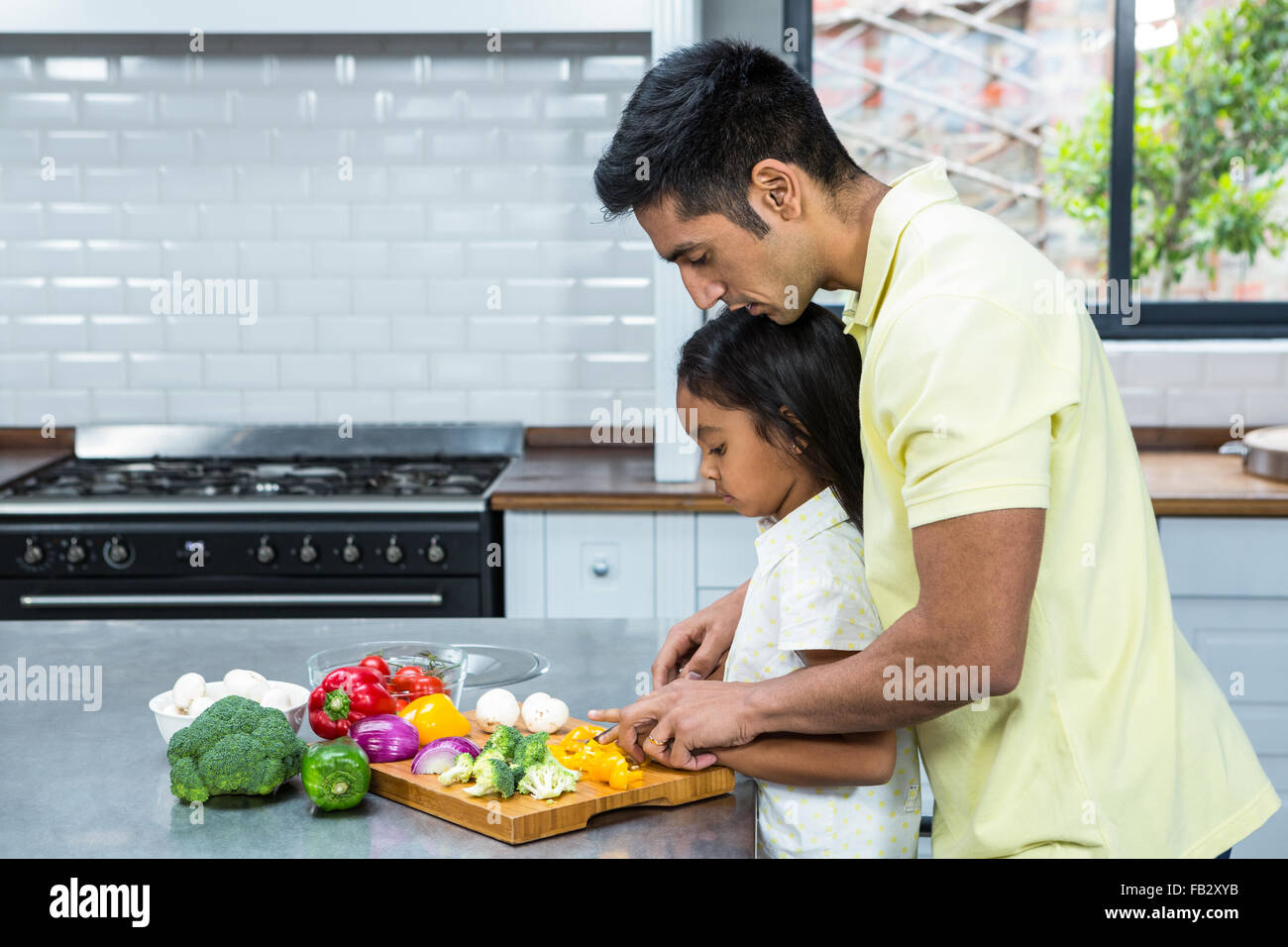 Art Vater helfen, seine Tochter Gemüse Schneiden Stockfoto
