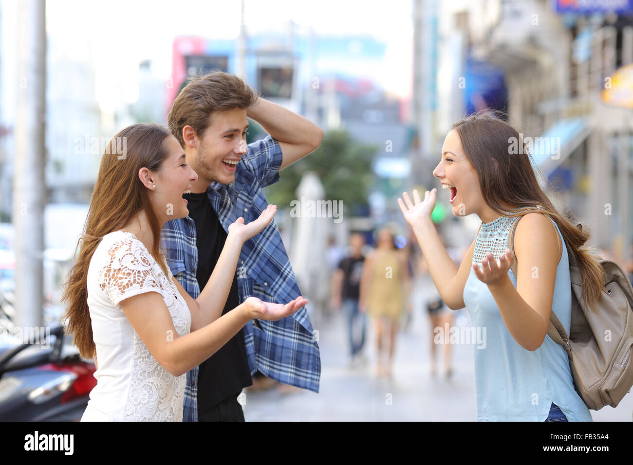 Drei glückliche Freunde treffen in der Straße von einer Großstadt Stockfoto