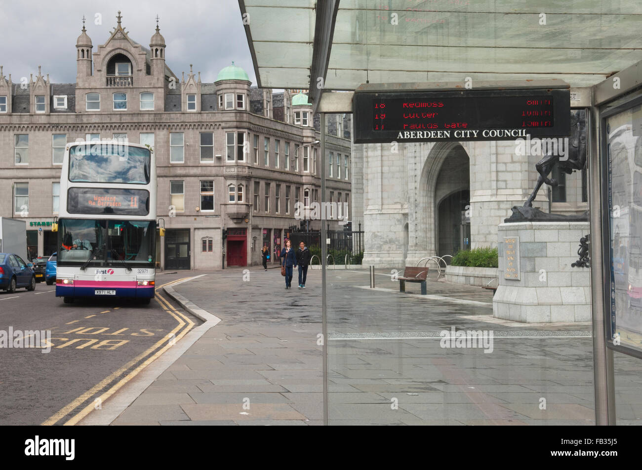 Bus nähert sich Bushaltestelle im Stadtzentrum von Aberdeen außerhalb Marischal College - Schottland, UK. Stockfoto