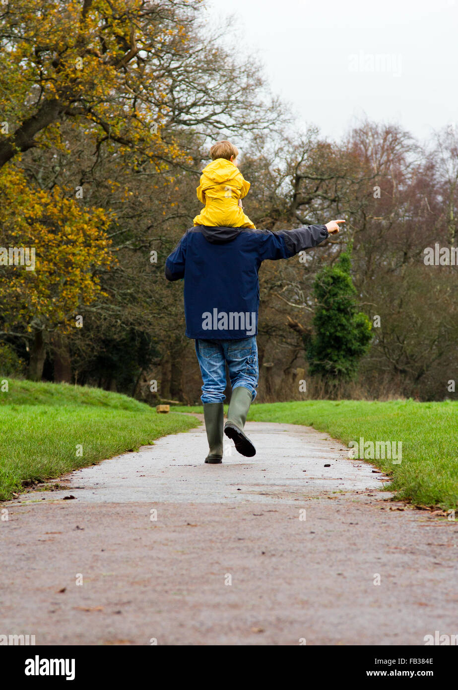 Vater und Sohn unter einem Winter Spaziergang in einem Park in Bristol, UK Stockfoto