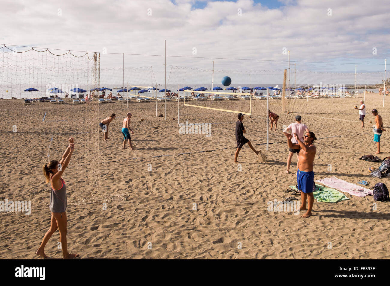 Gruppen von Jugendlichen spielen Beach-Volleyball am Strand Las Vistas in Los Cristianos, Teneriffa, Kanarische Inseln, Spanien. Stockfoto
