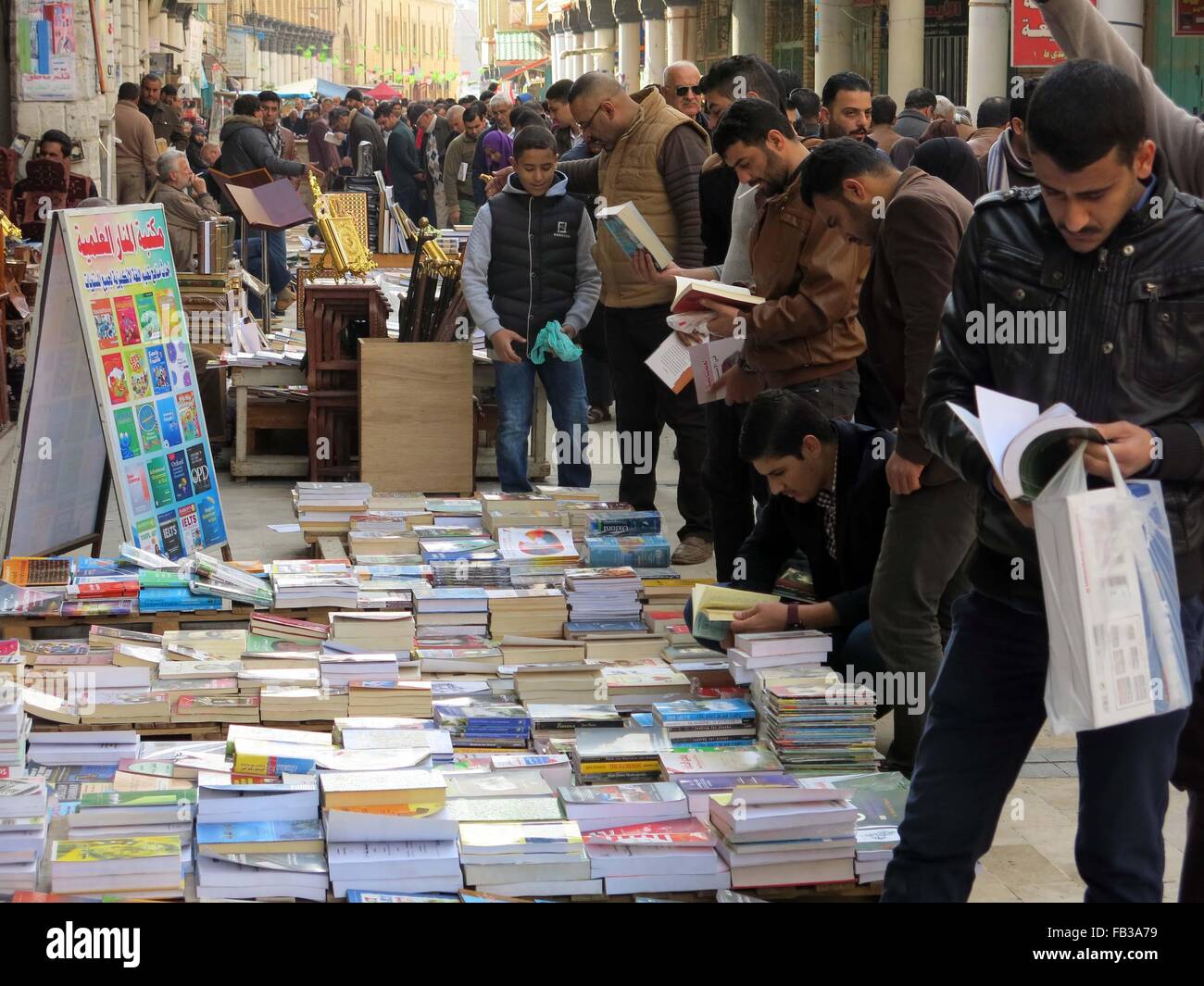 Bagdad, Irak. 8. Januar 2016. Menschen suchen Bücher an einem Outdoor-Buch-stand auf der Mutanabbi Straße, Bagdad, Irak, 8. Januar 2016. Mutanabbi Straße, in der Nähe der Altstadt von Bagdad, ist das historische Zentrum der Buchhandel, eine Straße voller Buchhandlungen und Outdoor-Buch Stände. © Khalil Dawood/Xinhua/Alamy Live-Nachrichten Stockfoto