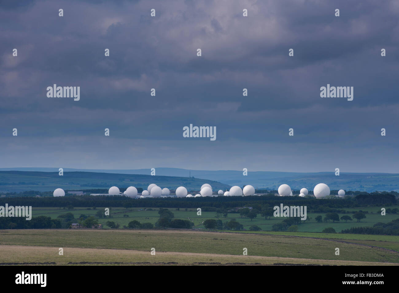 Unter dunklen Wolken in der Landschaft von North Yorkshire aussehen weißen Radome der RAF Menwith Hill, Harrogate, riesige Golfbälle. England, GB, UK. Stockfoto