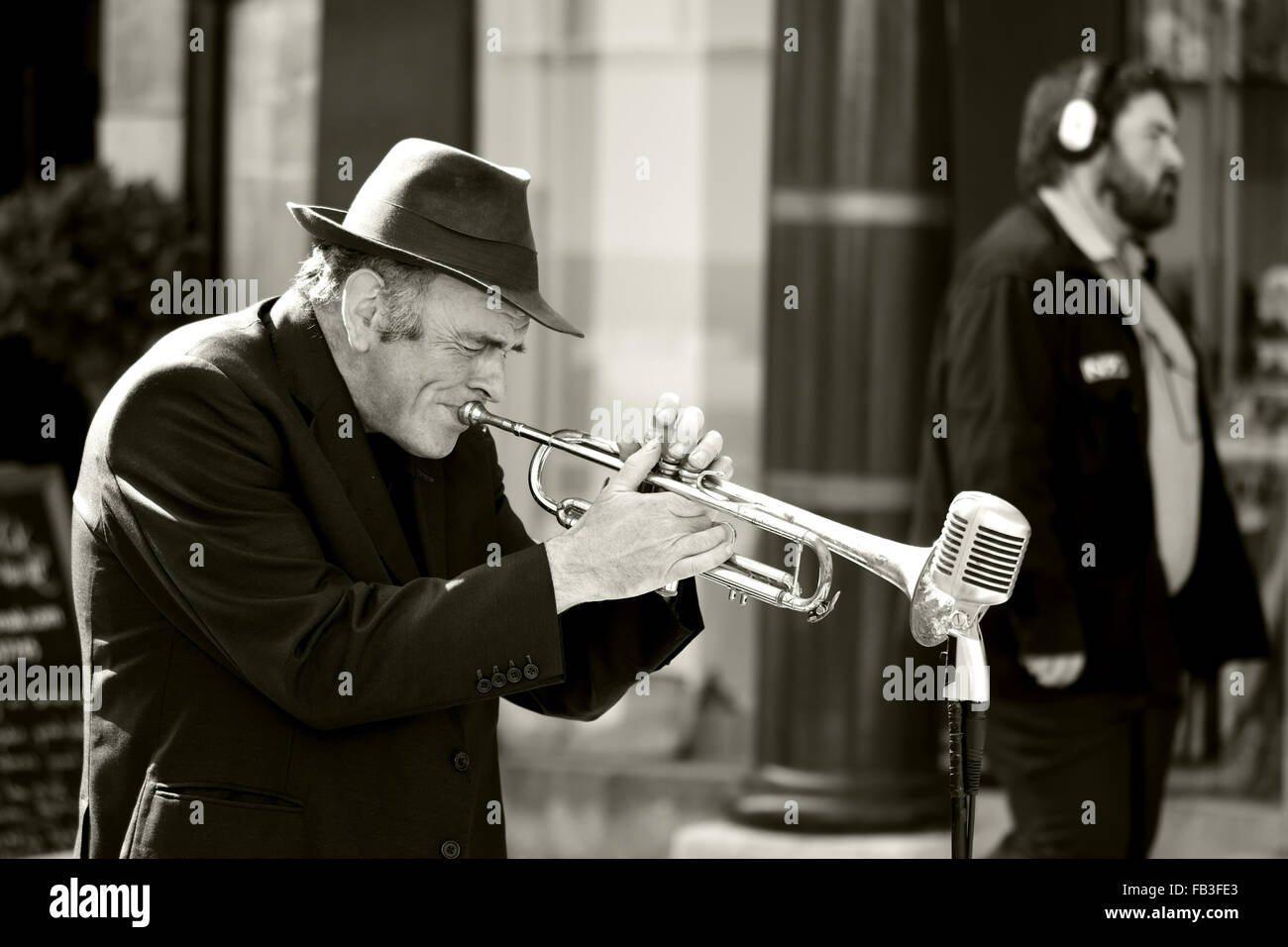 BATH, SOMERSET, Großbritannien - 12. September 2015 Mann spielt Trompete auf Straße von Mann mit Kopfhörer ignoriert Stockfoto