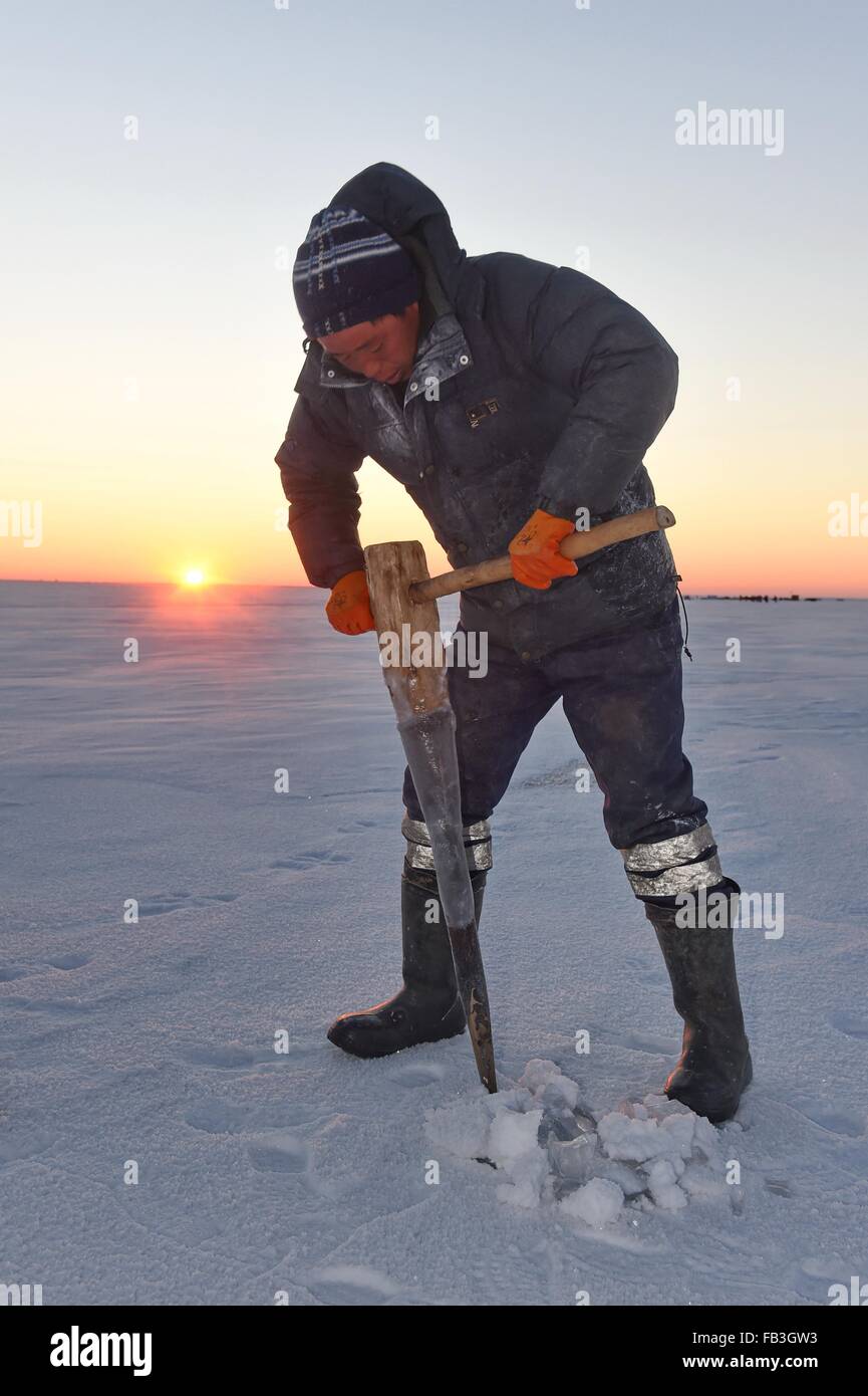 (160109)--SONGYUAN, 9. Januar 2016 (Xinhua)--ein Fischer bohrt eine Loch auf dickem Eis auf dem See Chagan Songyuan City, Nordost-China Jilin Province, 8. Januar 2016. Chagan See, der zum traditionellen Winter Angeln, die bis in prähistorische Zeiten zurückreicht bekannt ist, ist der einzige Ort, der die älteste mongolische Fangmethode speichert. Während der jährlichen Winter Angeln stattfindende Festival ist um zu erinnern, die alte Winter Fischertradition, Fischer zunächst viele Bohrungen durch das dicke Eis und dann ein Netz unter dem Eis. Das Netz wird schließlich von einem Pferd-Zeichnung Winde herausgezogen. Das See-set Stockfoto