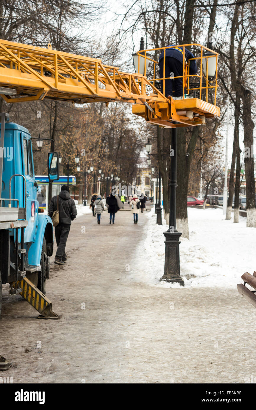 Arbeiter stehen einer mobilen Plattform Befestigung eine dekorative Straßenleuchte Stockfoto