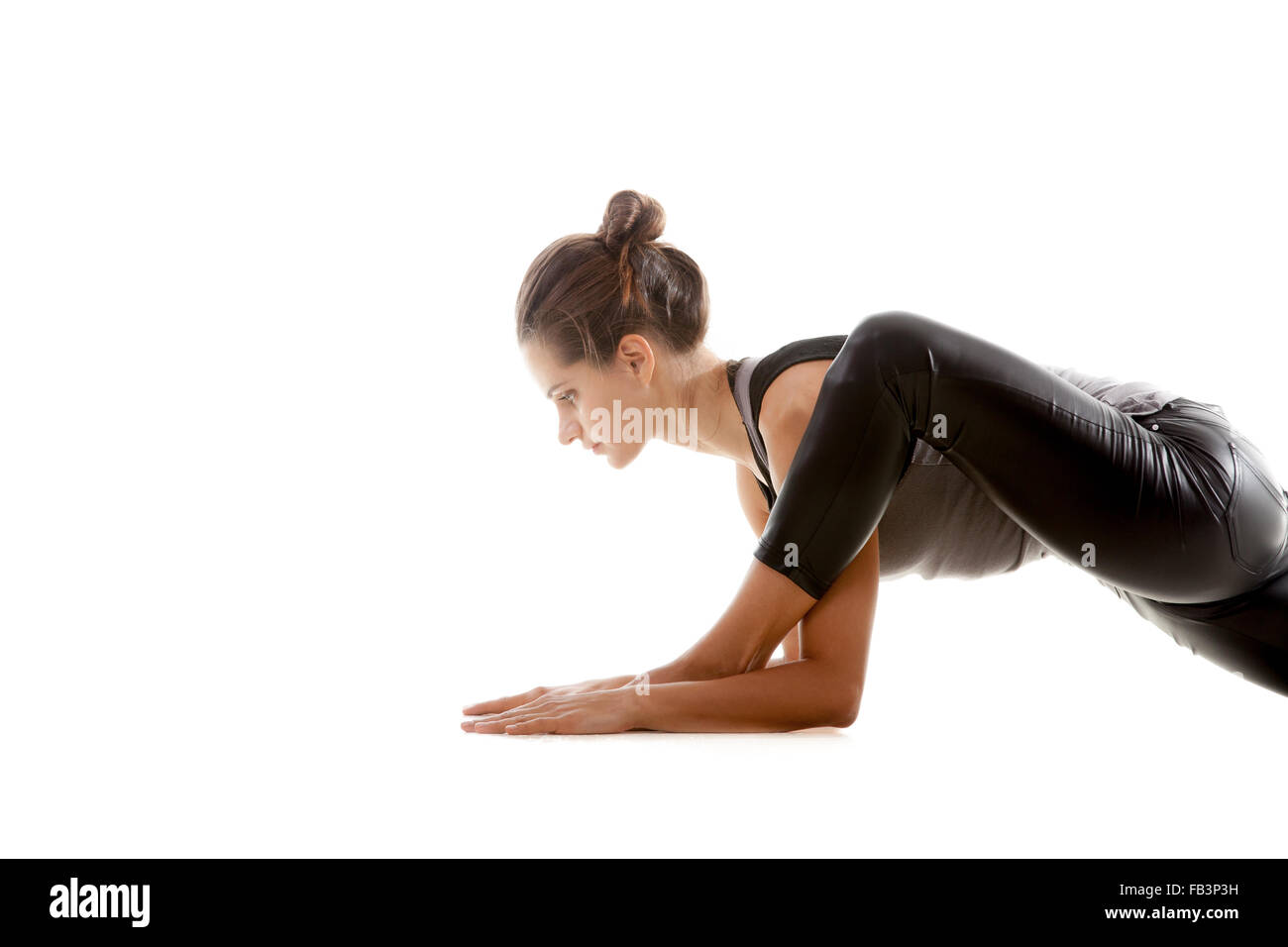 Sportliches Yoga Mädchen auf weißem Hintergrund ausübt, das linke Knie beugte sich über den linken Knöchel-Nahaufnahme Stockfoto