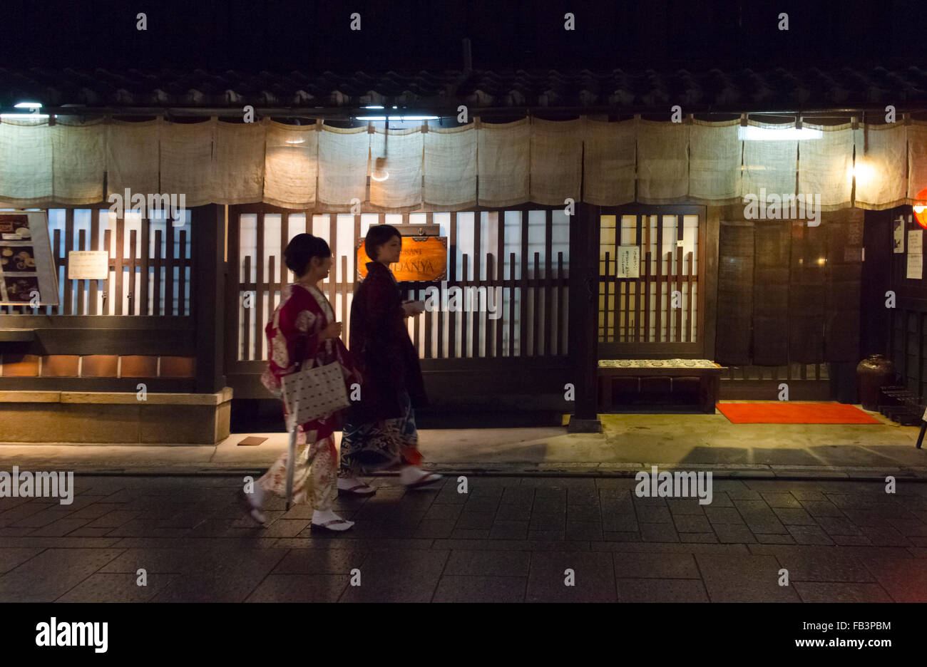 Frauen in traditionellen Kimonos zu Fuß auf schmale Spur der traditionellen Häuser in Hanami-Koji Straße im Stadtteil Gion, Kyoto, Japan Stockfoto