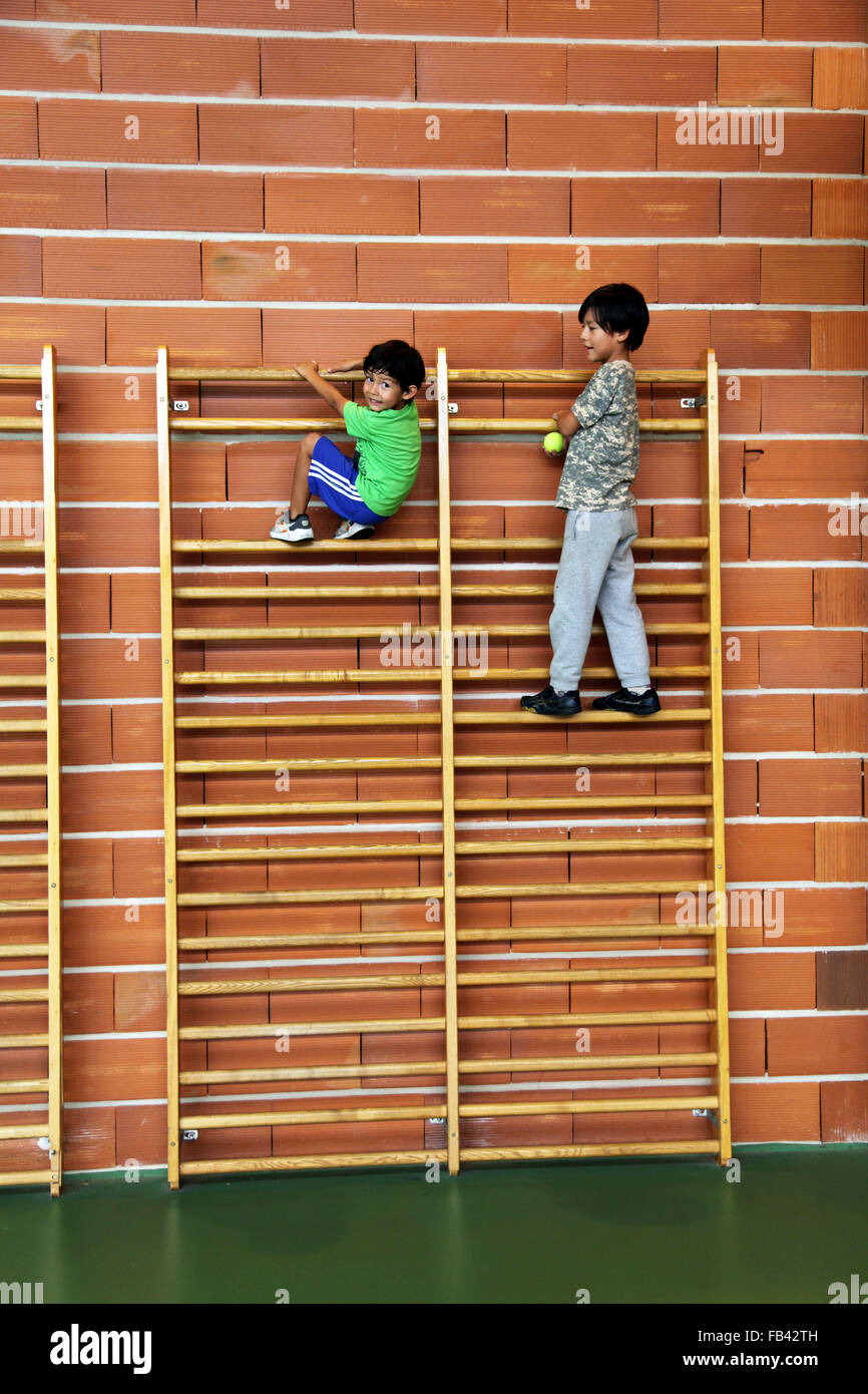 Es ist ein Foto von 2 Jungs an der Spitze einer hölzernen Leiter in ein Sportzentrum. Stockfoto
