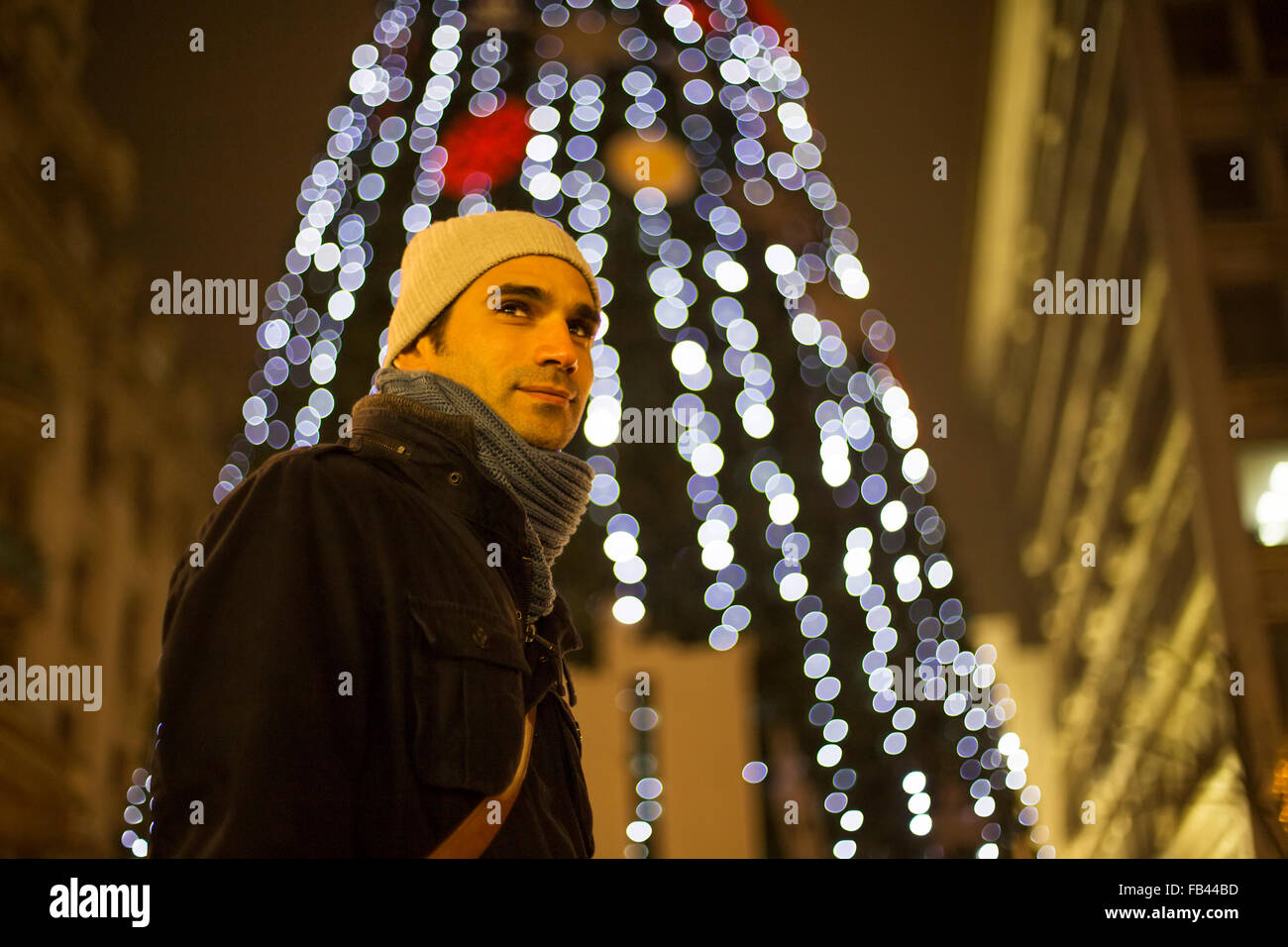 Junger Mann im Freien mit Weihnachtsdekoration Stockfoto