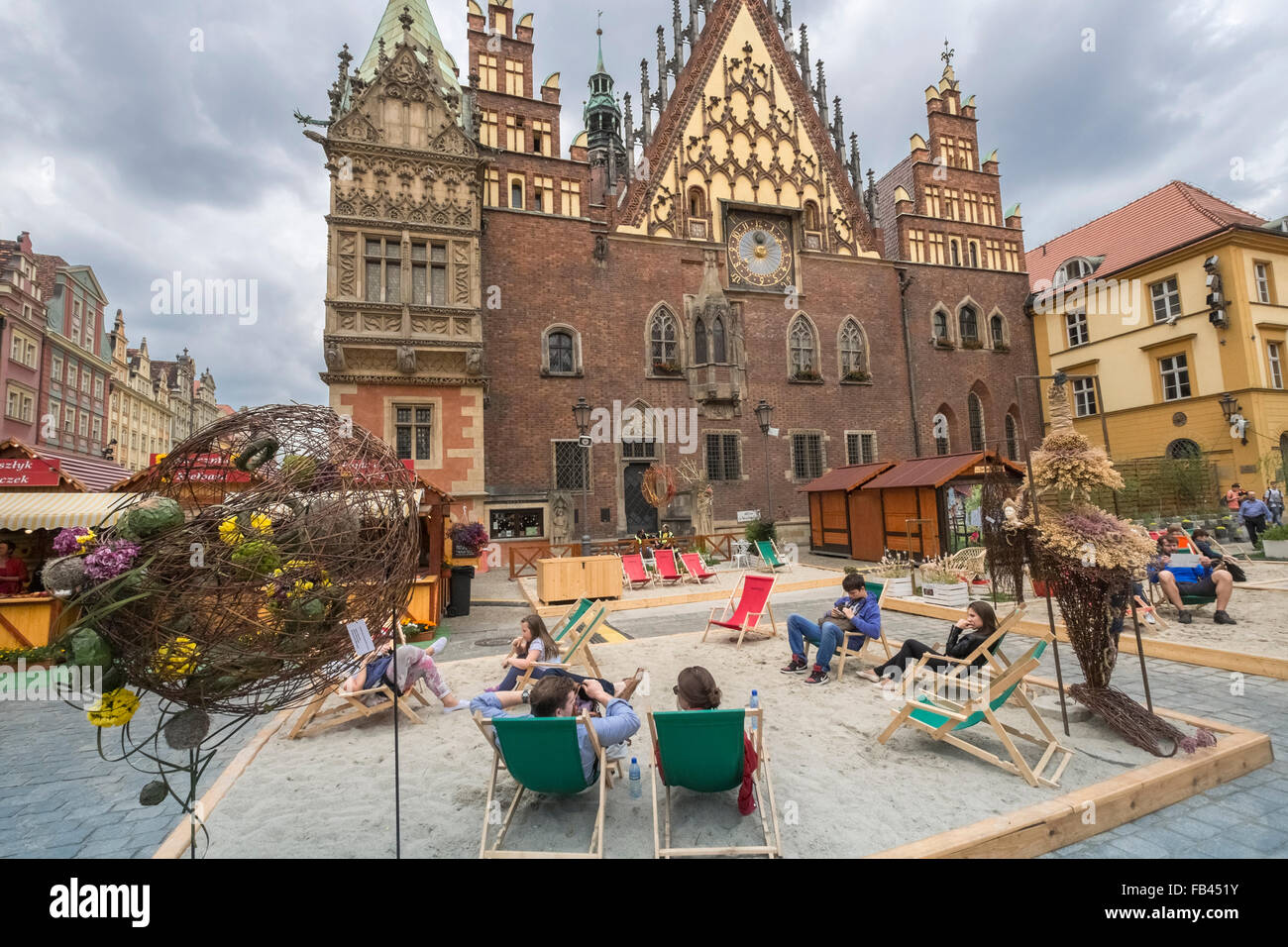 Touristen sitzen außen Ostseite von Breslau gotische Rathaus, Marktplatz, Altstadt, Wroclaw, Polen Stockfoto