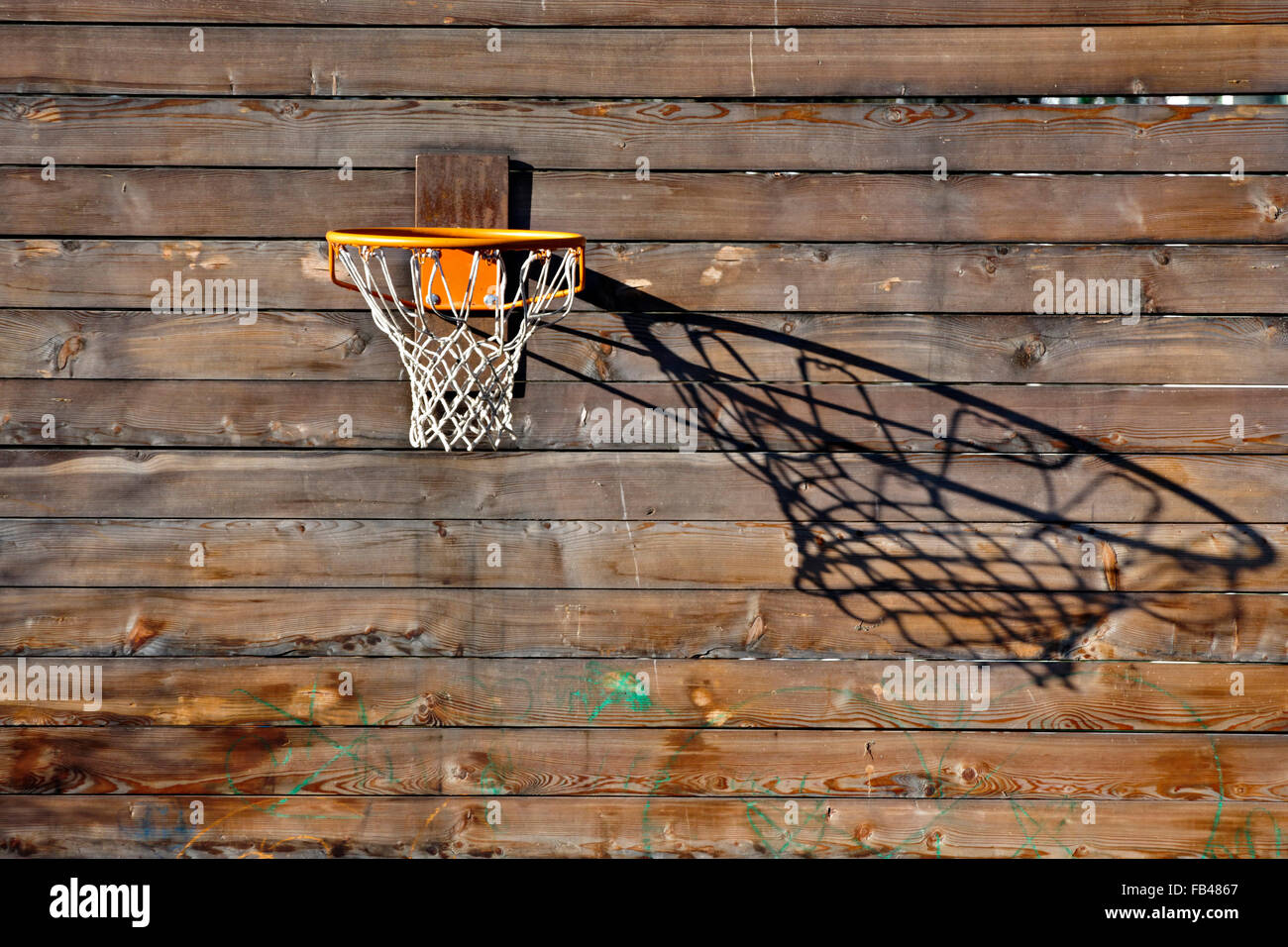 Basketball net wirft einen Schatten auf Holzwand Stockfoto