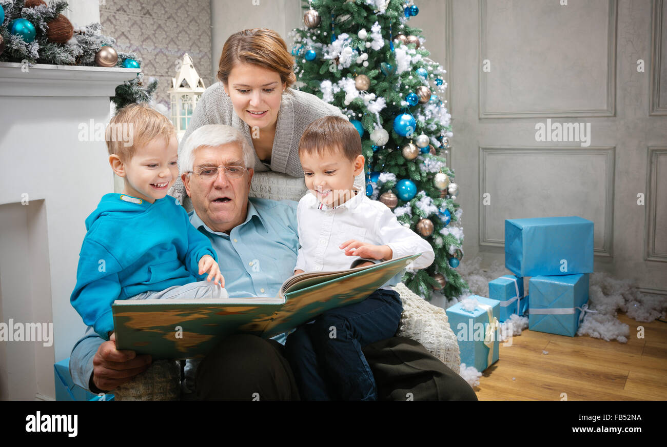 Drei-Generationen-Familie ein Buch zu lesen, an Heiligabend zu Hause Stockfoto