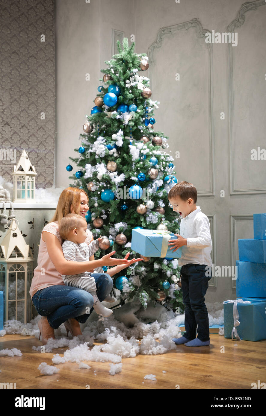 Junge Mutter, ein Geschenk, des ältesten Sohnes, Baby Boy berühren Christbaumkugel am Weihnachtsbaum Stockfoto
