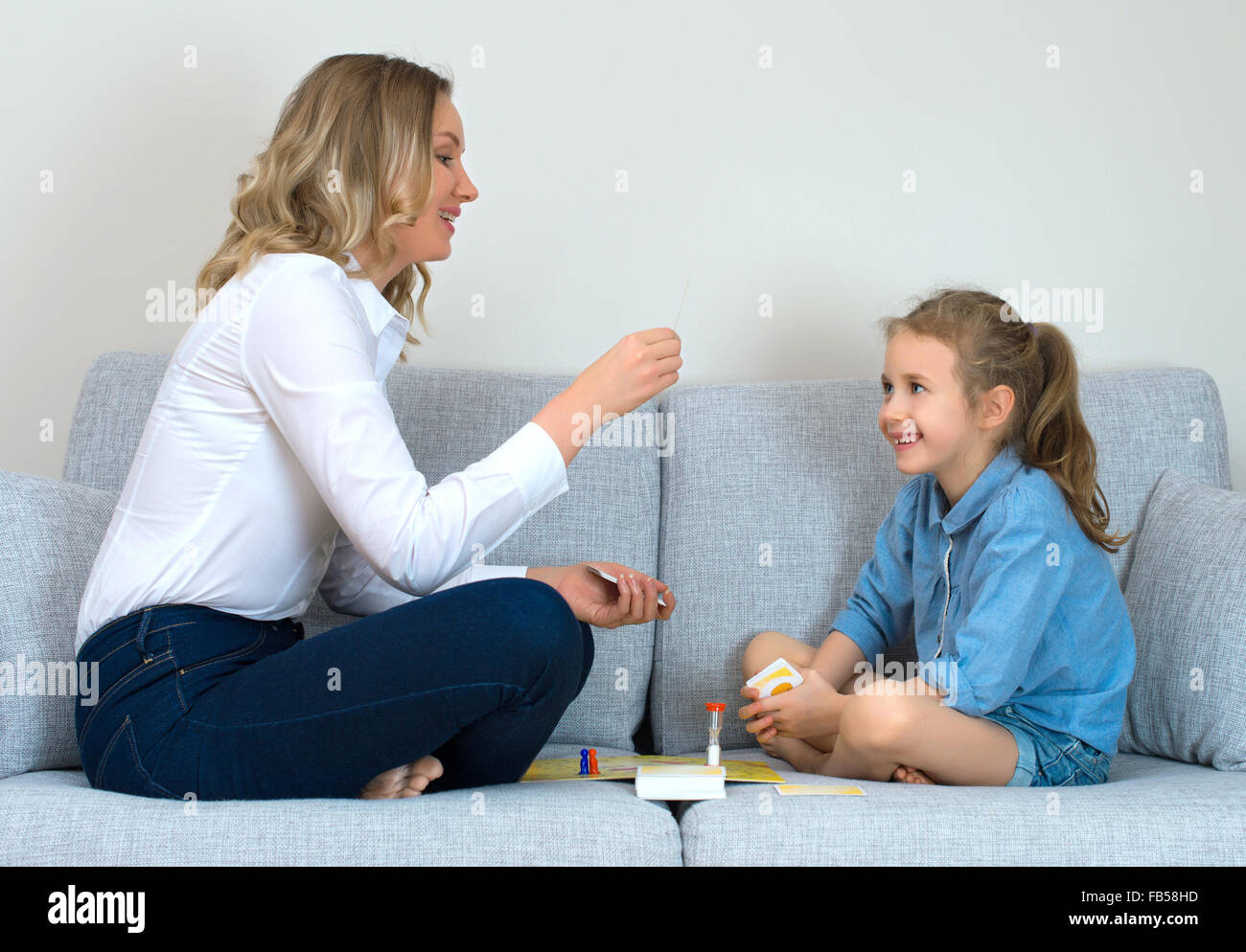 Mutter und Tochter spielen Brettspiel zu Hause. Stockfoto