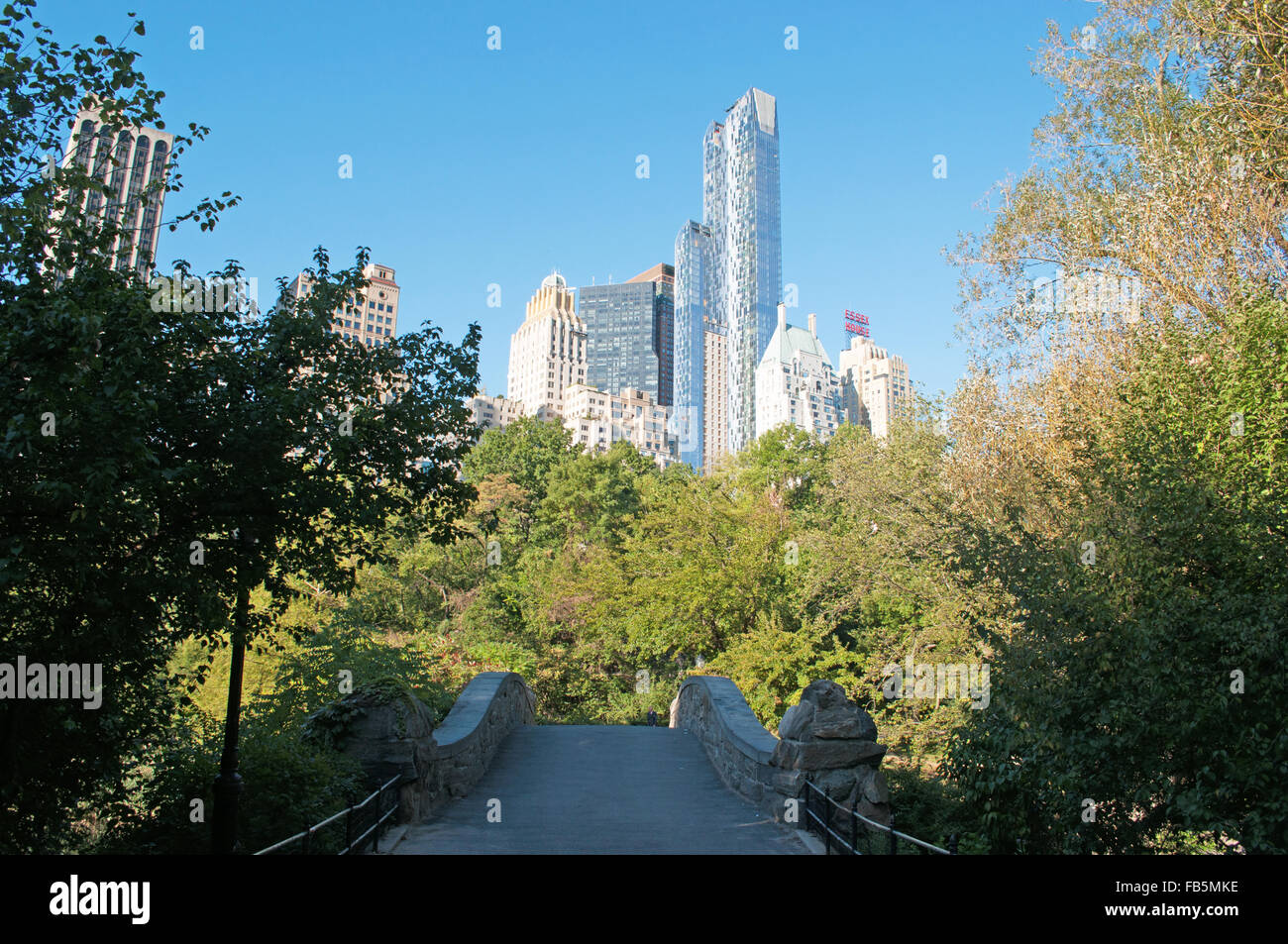 Usa: die Skyline von New York mit seinen Wolkenkratzern von einer Brücke aus Stein im Central Park, der berühmtesten öffentlichen Park der Welt gesehen, Stockfoto