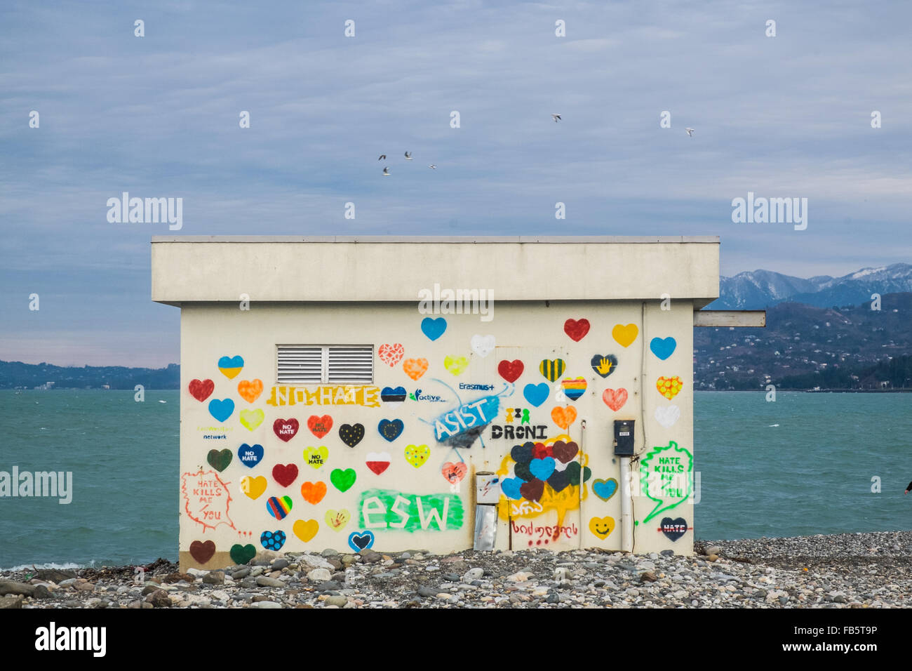 Batumi, Georgien | Graffiti auf kleine Gebäude mit Meer im Hintergrund Stockfoto