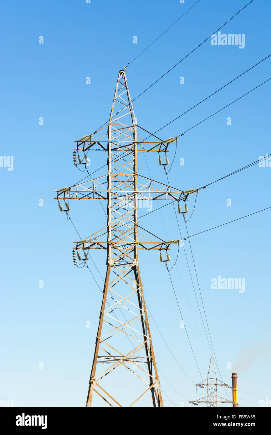 Unterstützungen für Hochspannungs-Stromleitung gegen den blauen Himmel. Stockfoto
