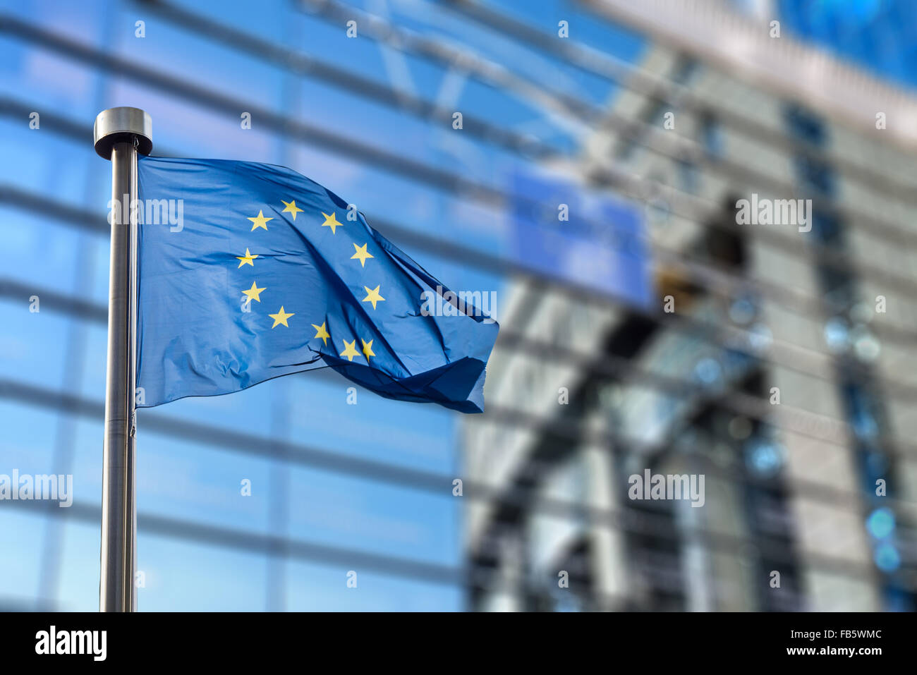 Europäische Union Flaggen vor dem unscharfen Europaparlament in Brüssel, Belgien Stockfoto