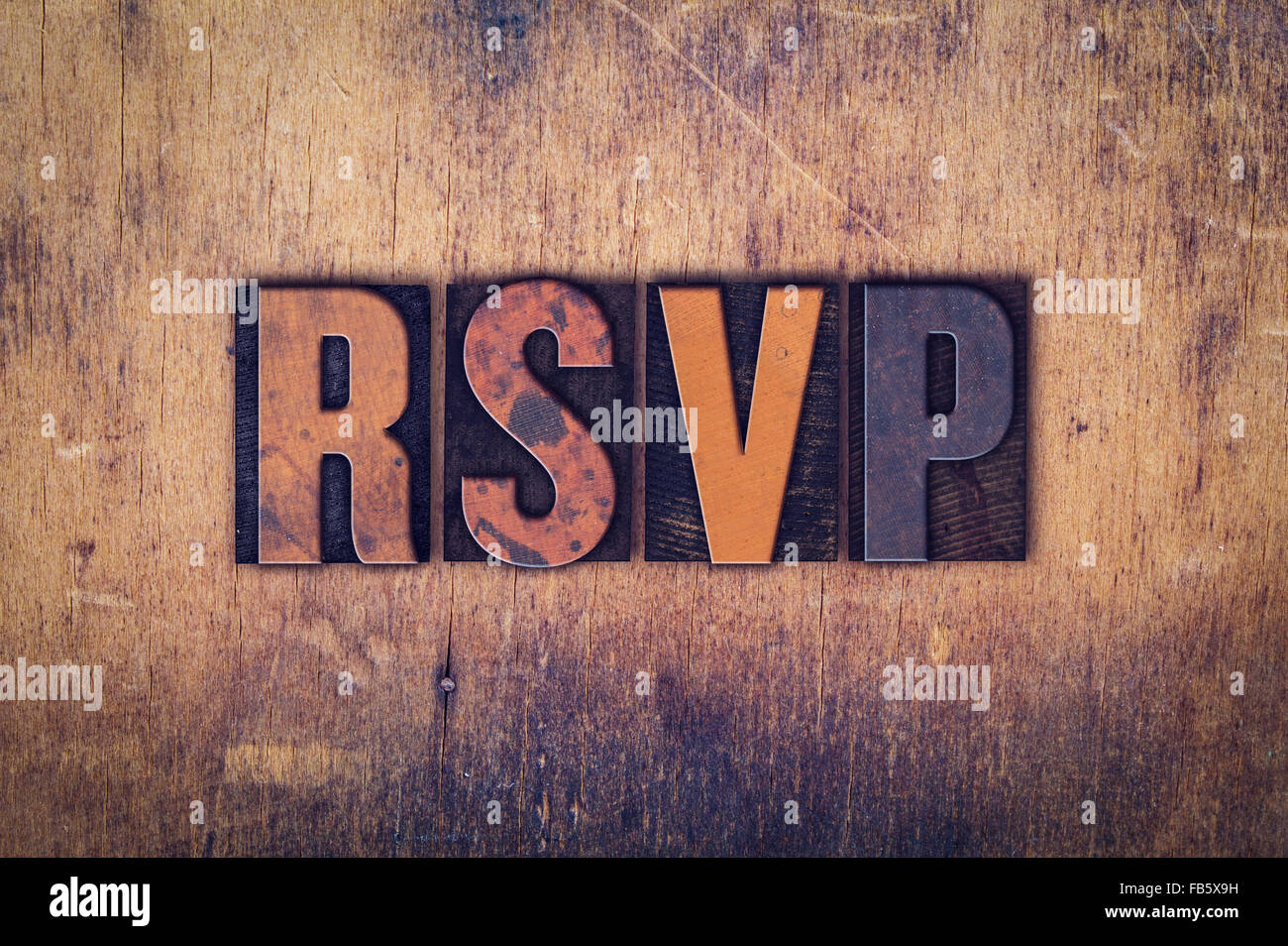 Das Wort "RSVP" in schmutzigen Vintage Buchdruck Typ auf einem alten hölzernen Hintergrund geschrieben. Stockfoto