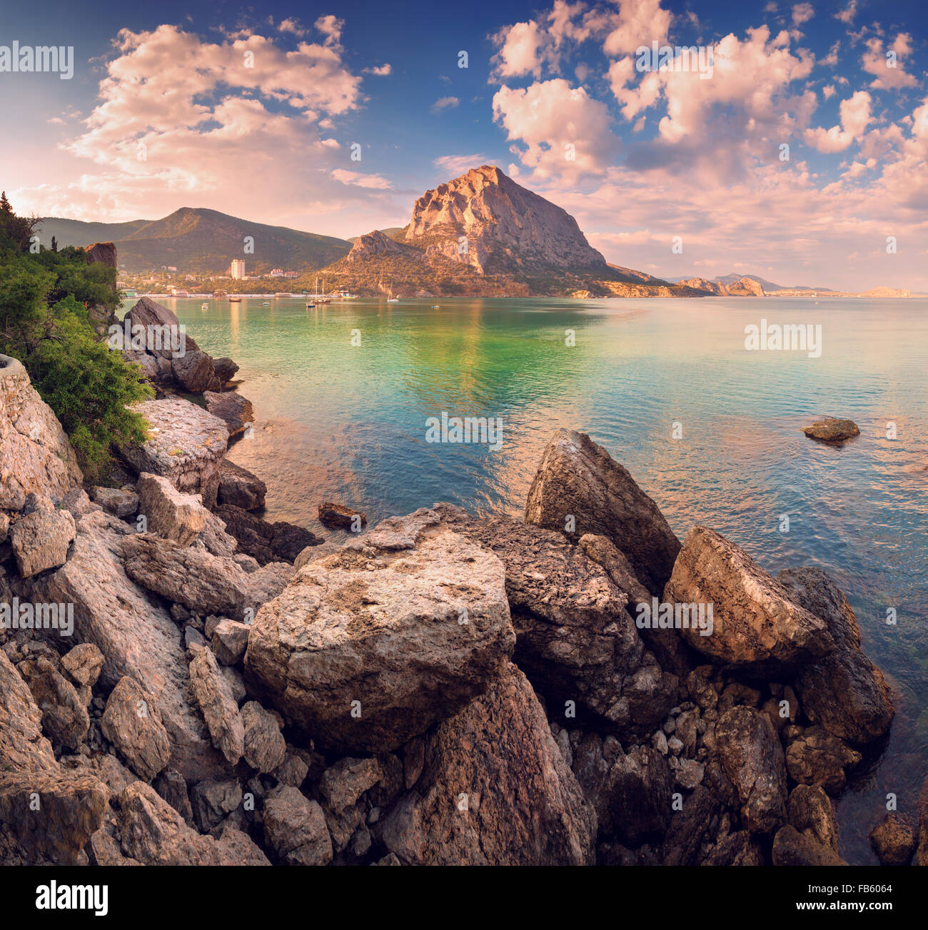 Schönen Sommer Sonnenuntergang am Meer mit Bergen und Steinen auf der Krim Stockfoto