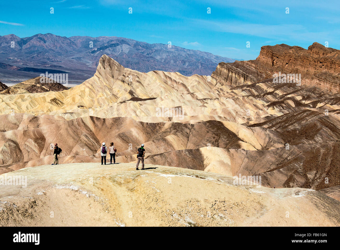 Menschen, die in der Ansicht von Death Valley berühmten Zabriskie Point der umliegenden Wüste Berge. Stockfoto