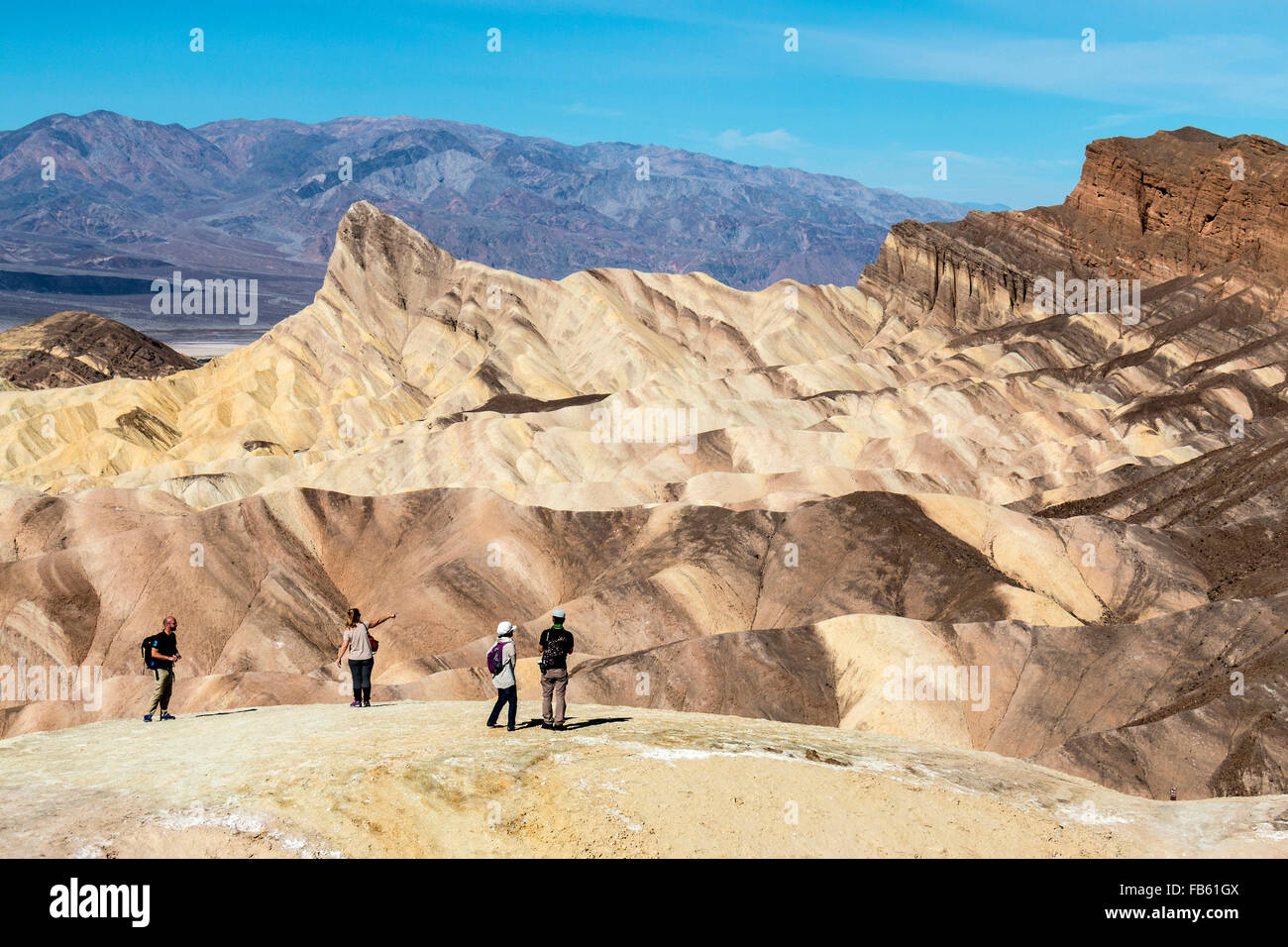 Menschen, die in der Ansicht von Death Valley berühmten Zabriskie Point der umliegenden Wüste Berge. Stockfoto