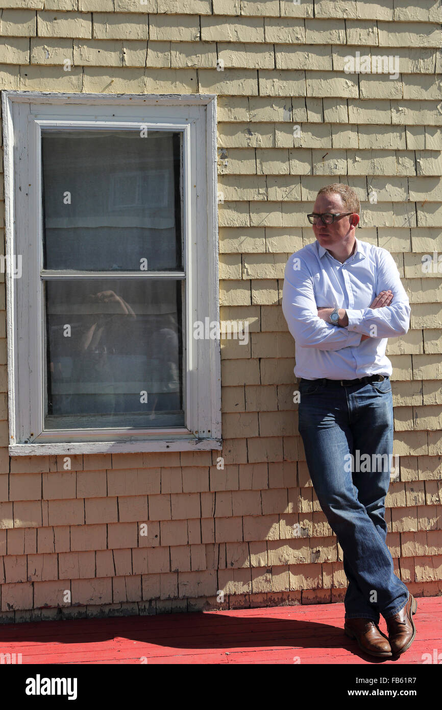 Ein Mann vor einem Haus in Mahone Bay in Nova Scotia, Kanada. Ein Mann steht durch die Fassade. (Modell freigegeben.) Stockfoto