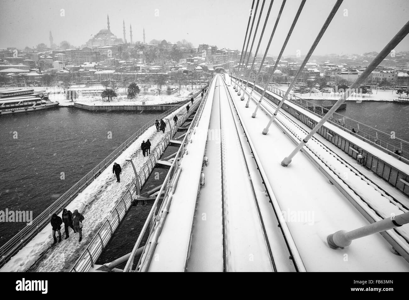 Menschen zu Fuß auf das Goldene Horn-U-Bahn-Brücke an einem verschneiten Tag, 2016. Stockfoto