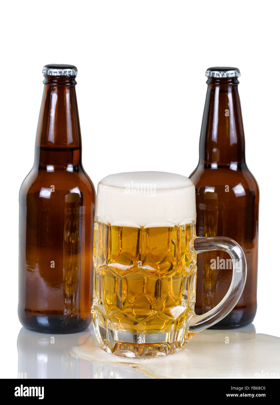 Golden gefärbt Bier fließt aus Glas Becher mit zwei vollen Flaschen im Hintergrund. Isoliert auf weiss mit Reflexion. Stockfoto