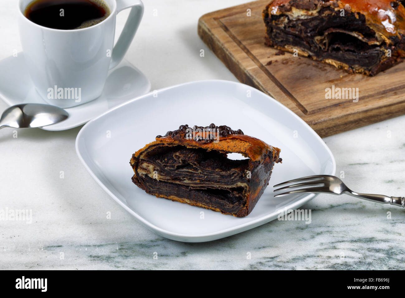 Nahaufnahme eines einzelnen Segments Schokoladenkuchen mit Blaubeeren in weißen Teller mit Gabel. Stockfoto