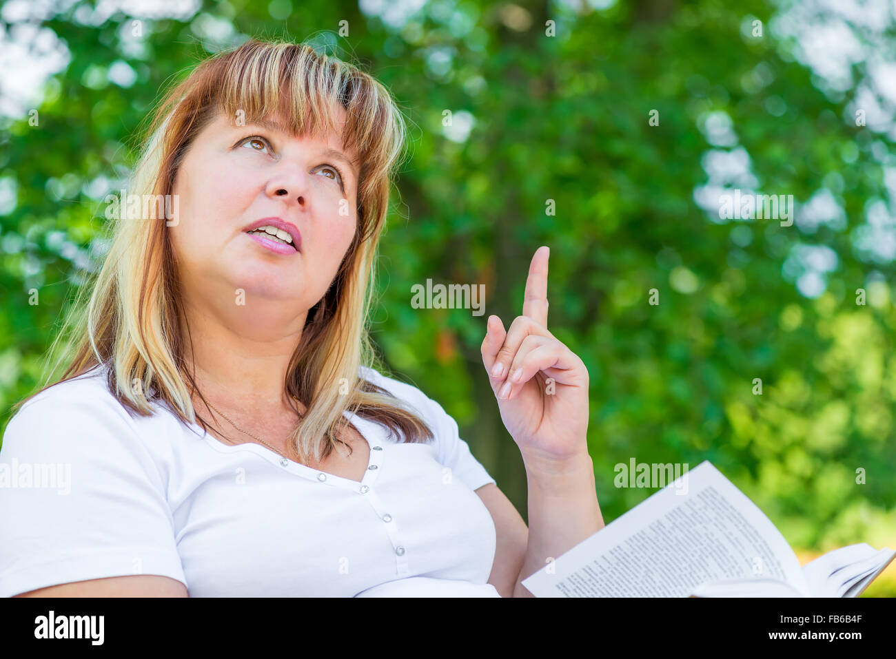 Betroffenen Frau mit Buch über etwas denken Stockfoto