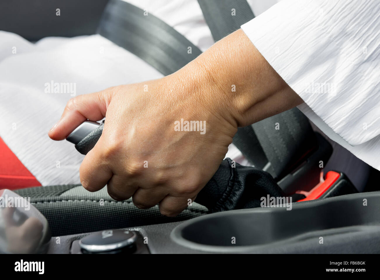 zarte Frauenhand und die Handbremse des Auto-Close-up Stockfoto