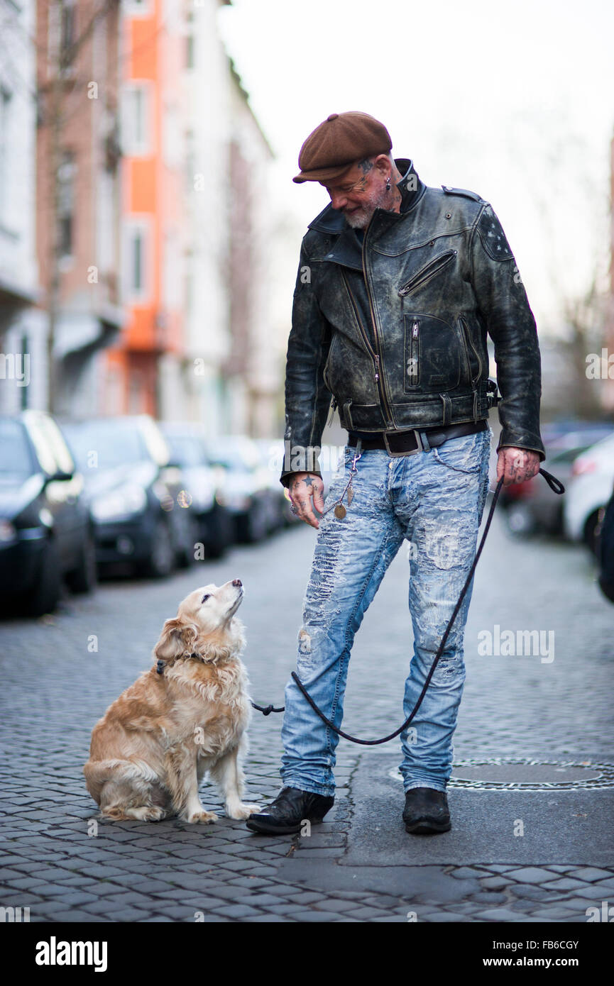 Tätowierte Männer mit seinem Hund auf der Straße von Düsseldorf (MR) Stockfoto