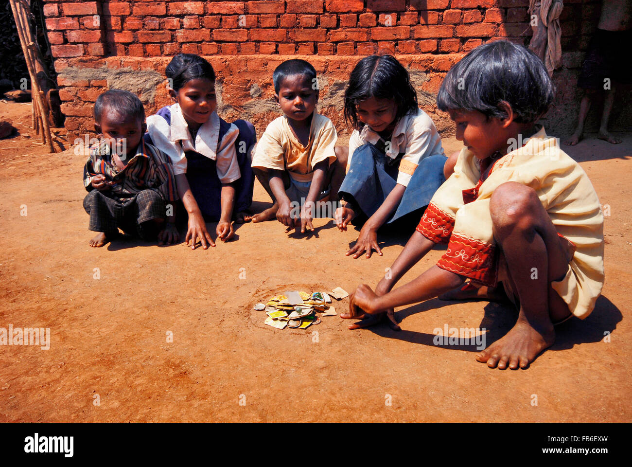 MA Thakar Stamm, Maharashtra, Kinder spielen mit Flasche Deckel, Ahupe Village, Indien Stockfoto