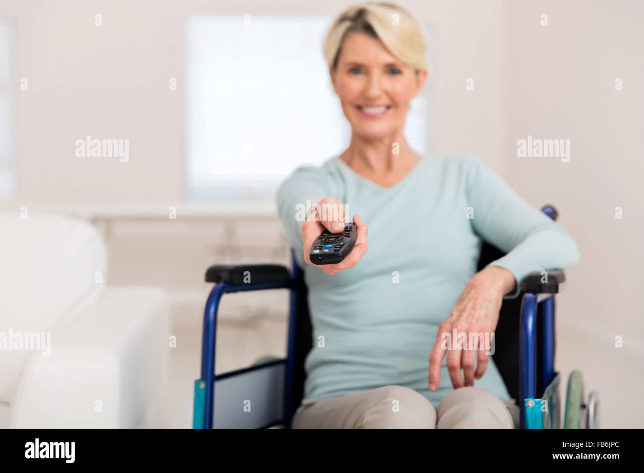 Frau im Rollstuhl, die Filme zu Hause deaktiviert Stockfoto