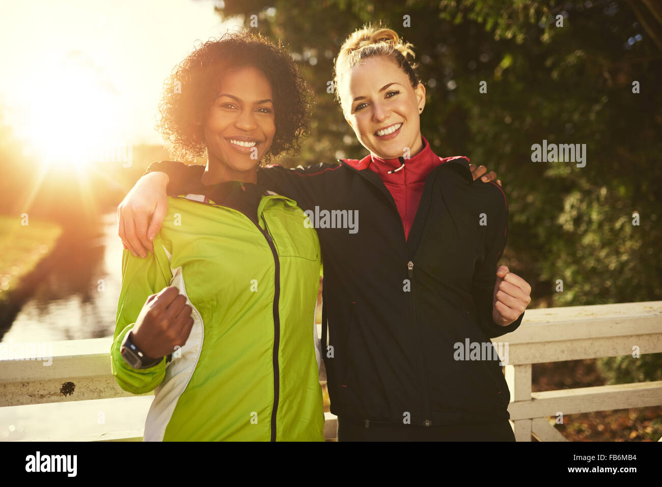 Zwei junge Sportlerinnen umarmt und Blick in die Kamera, zeigt, dass sie stark sind Stockfoto
