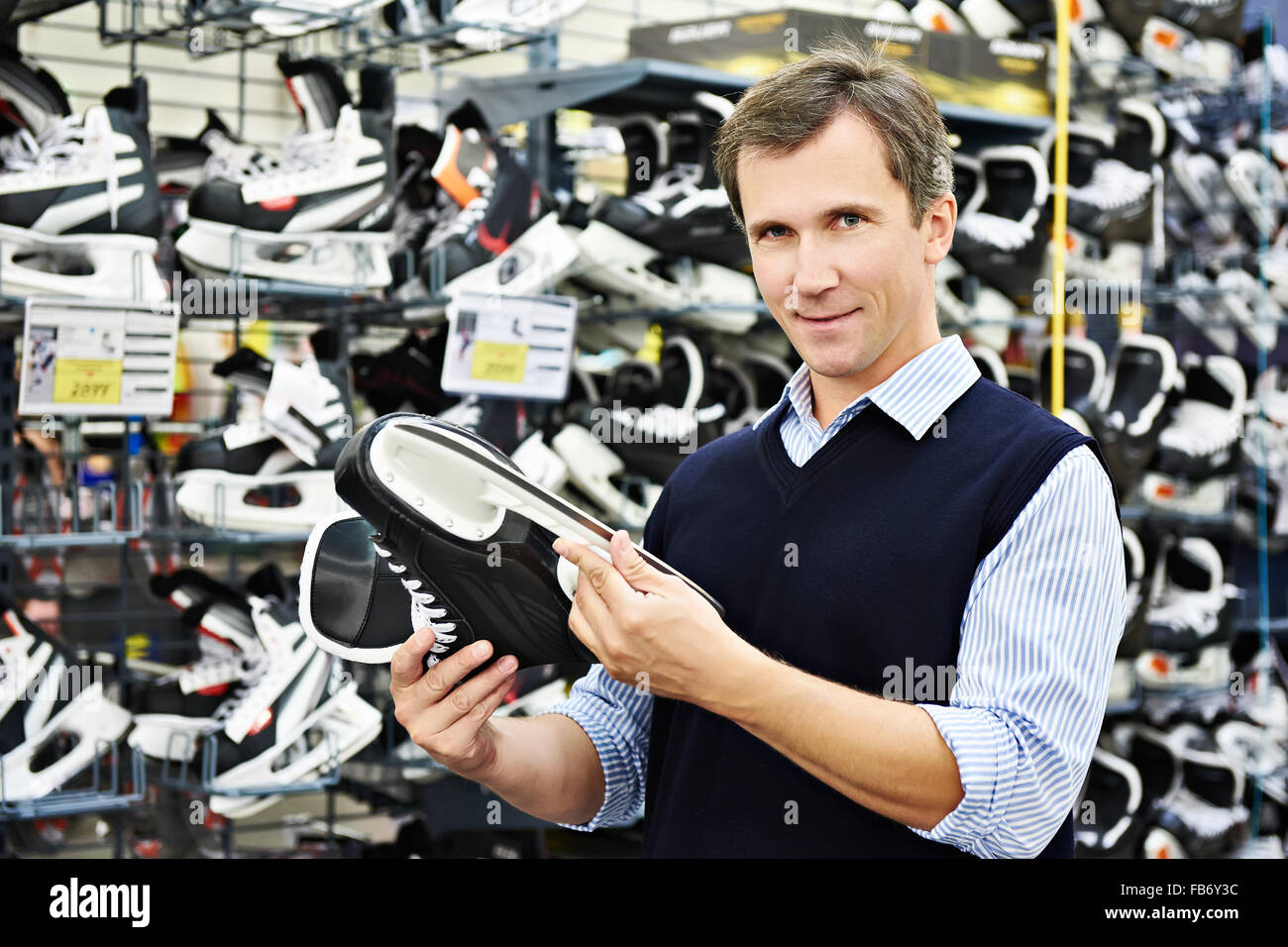 Man wählt Hockey Schlittschuhe im Sportgeschäft Stockfoto