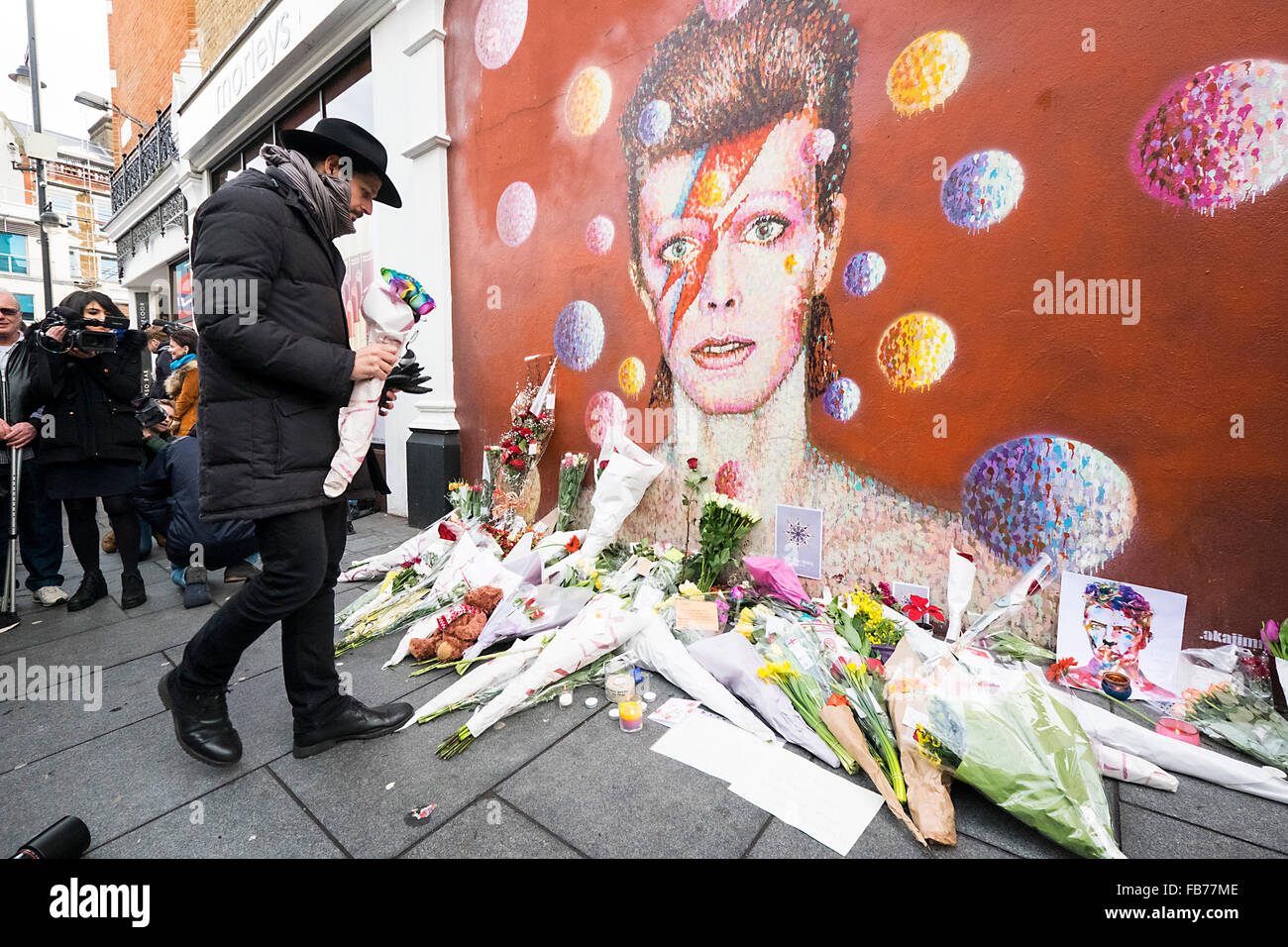 Ein Wandbild von David Bowie mit Ehrungen und Blumen Stockfoto