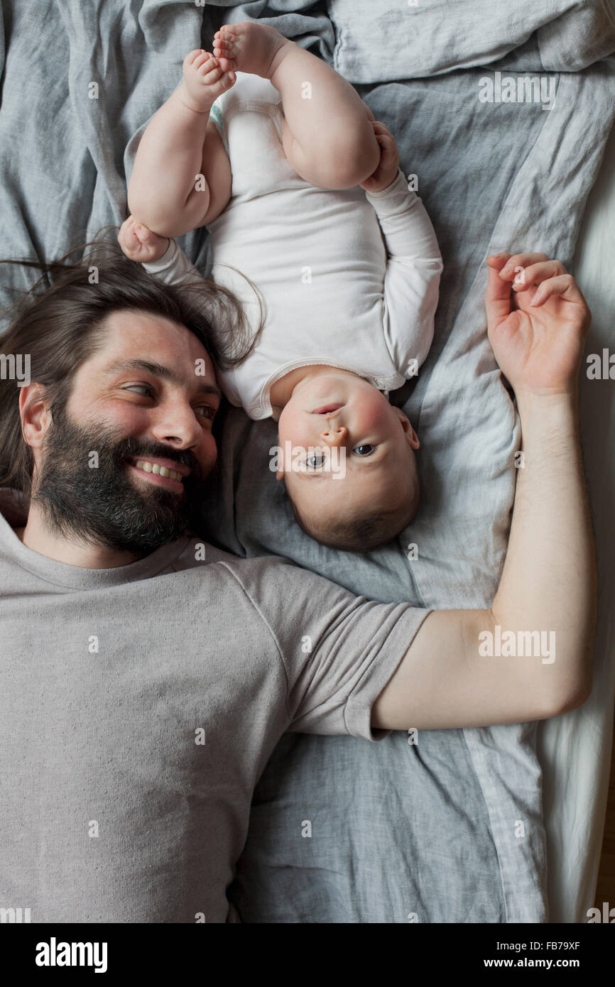 Direkt über dem Bild von Vater und Baby Mädchen im Bett liegend Stockfoto