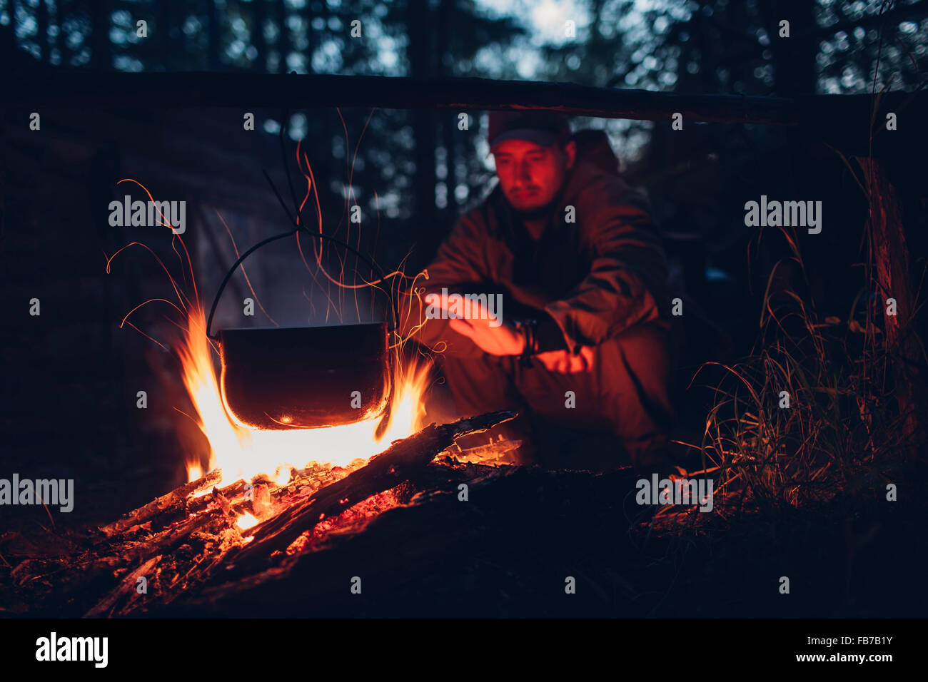 Mitte erwachsenen Mannes Erwärmung Hände auf Campingplatz Stockfoto