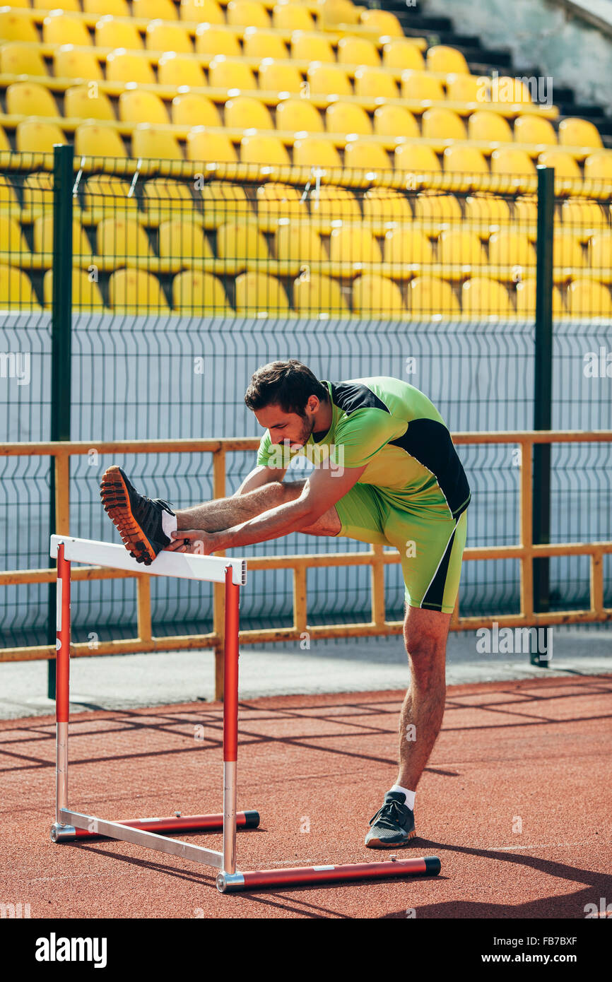 Gesamte Länge der Leichtathletin und Olympiateilnehmerin Aufwärmen auf Hürde Stockfoto