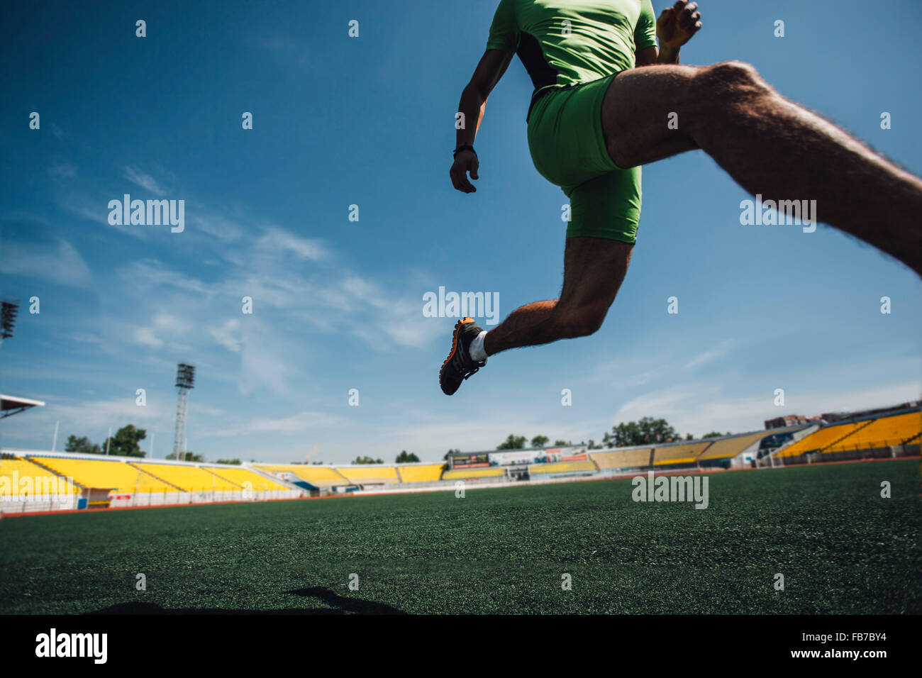 Niedrige Teil der junge Athlet läuft auf Feld im Stadion Stockfoto